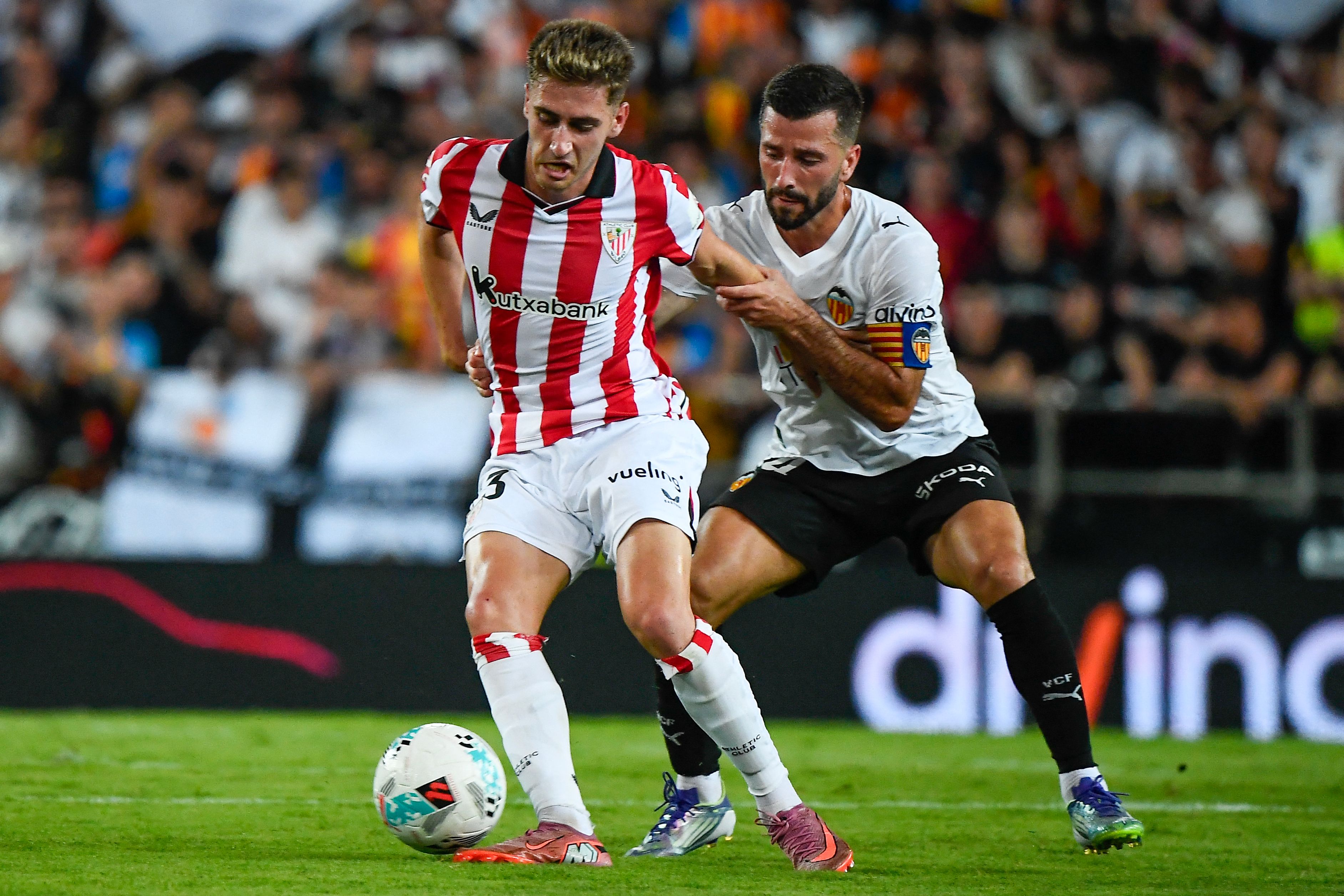 Athletic Bilbao's Spanish forward #23 Robert Navarro (L) vies for the ball with Valencia's Spanish defender #14 Jose Gaya during the Spanish league football match between Valencia CF and Athletic Club Bilbao at the Mestalla stadium in Valencia, on September 20, 2025. (Photo by Jose Jordan / AFP)