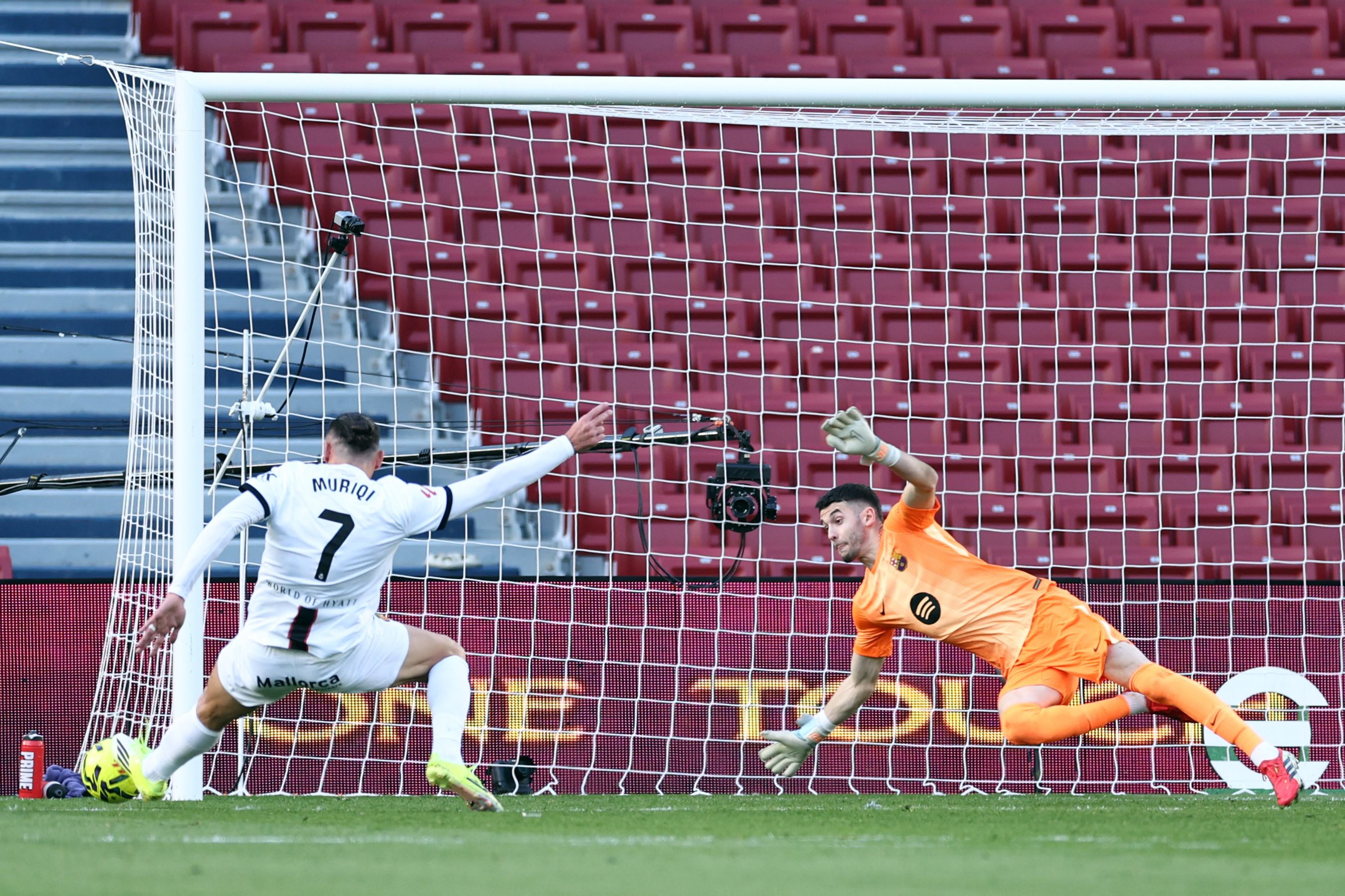Barcelona's Spanish goalkeeper #13 Joan Garcia (R) dives as Real Mallorca's Kosovo forward #07 Vedat Muriqi attempts to score during the Spanish league football match between FC Barcelona and RCD Mallorca at Camp Nou Stadium in Barcelona on February 7, 2026. (Photo by Josep LAGO / AFP)