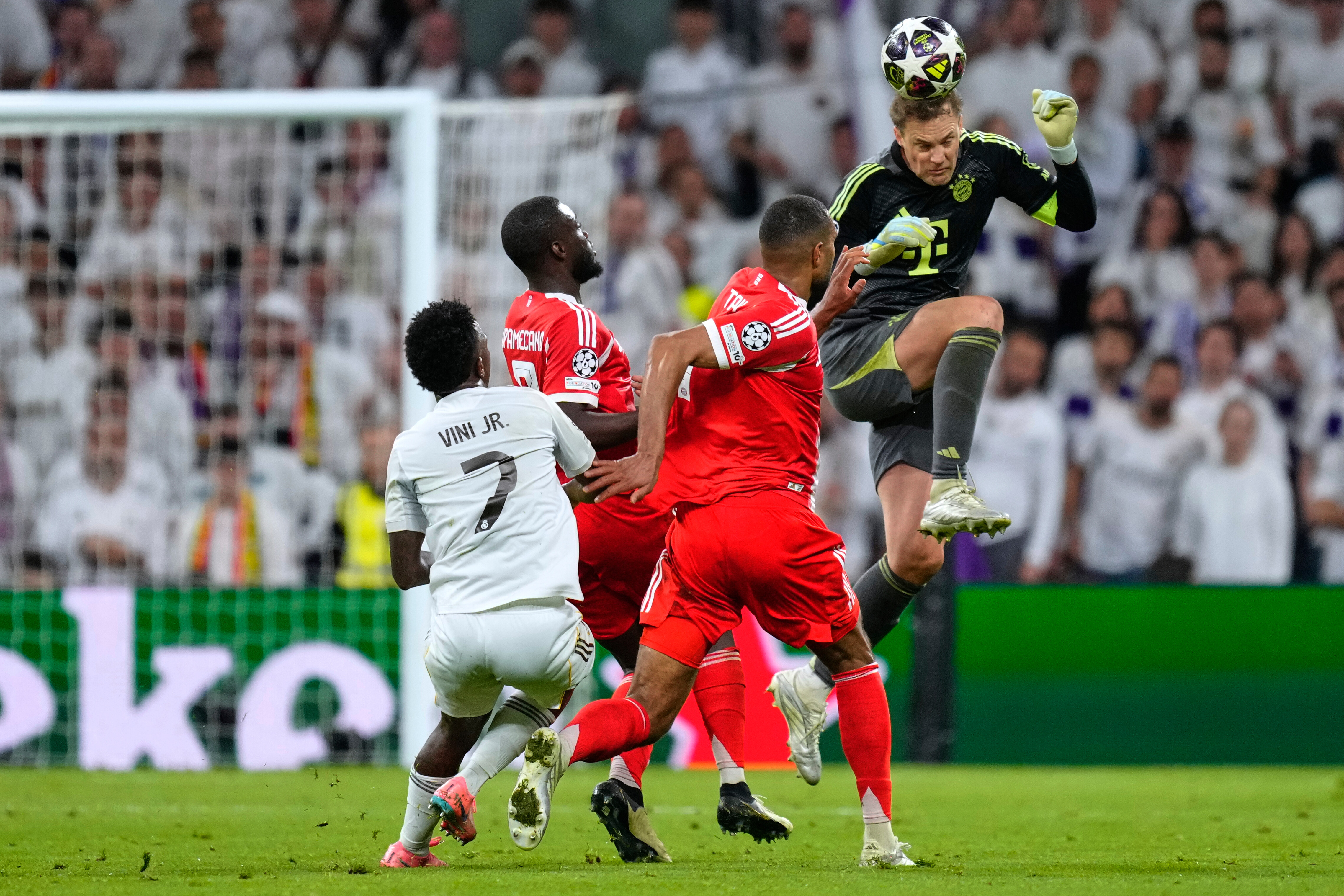 Bayern's goalkeeper Manuel Neuer heads the ball to save before Real Madrid's Vinicius Junior, left, can score during the Champions League quarterfinal first leg soccer match between Real Madrid and Bayern Munich in Madrid, Spain, Tuesday, April 7, 2026. (AP Photo/Jose Breton)