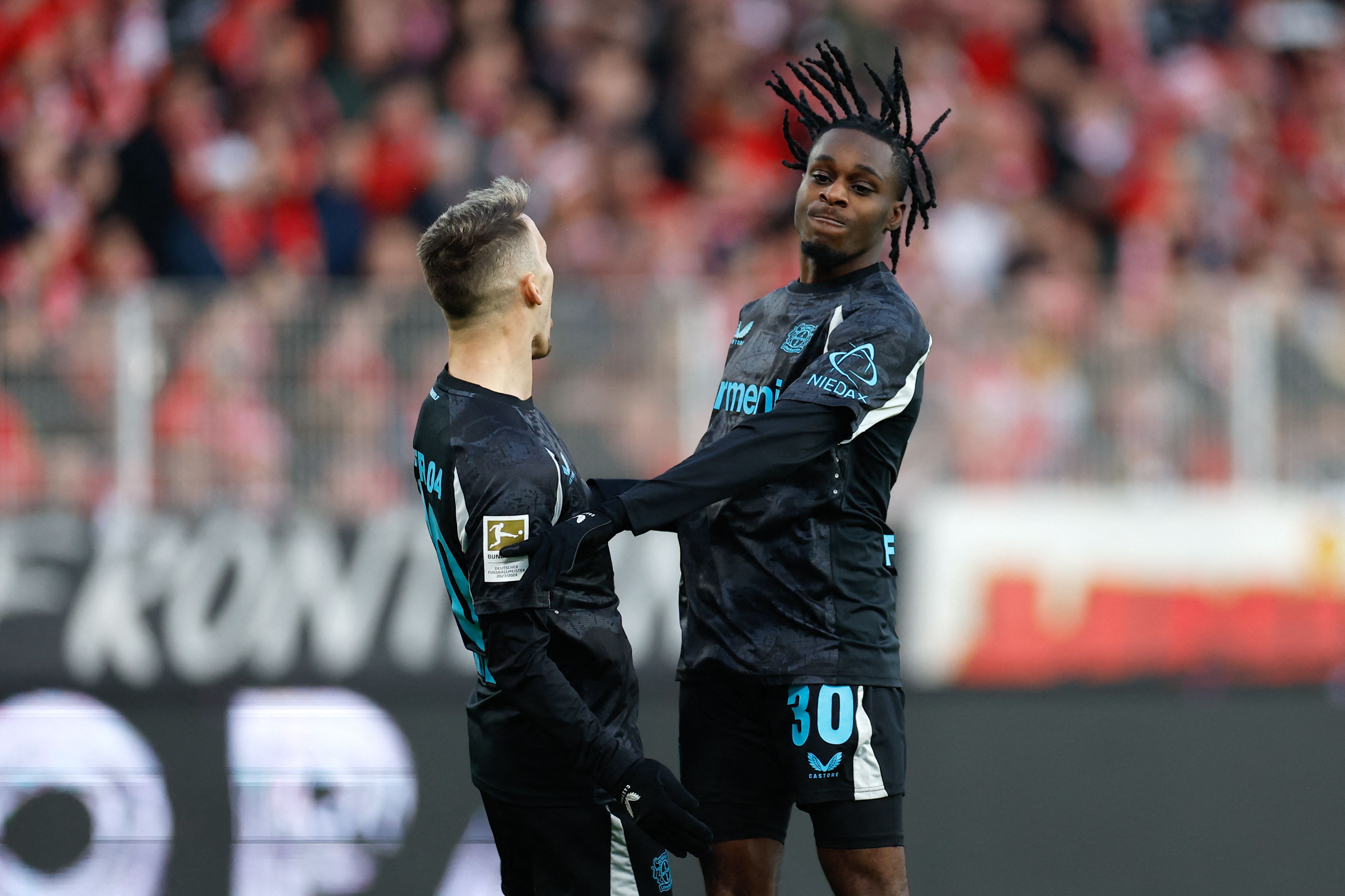 Bayer Leverkusen's Dutch defender #30 Jeremie Frimpong (R) celebrates scoring his team's first goal with Bayer Leverkusen's Spanish defender #20 Alejandro Grimaldo during the German first division Bundesliga football match between 1 FC Union Berlin and Bayer 04 Leverkusen in Berlin, on November 30, 2024. (Photo by Odd ANDERSEN / AFP) / DFL REGULATIONS PROHIBIT ANY USE OF PHOTOGRAPHS AS IMAGE SEQUENCES AND/OR QUASI-VIDEO