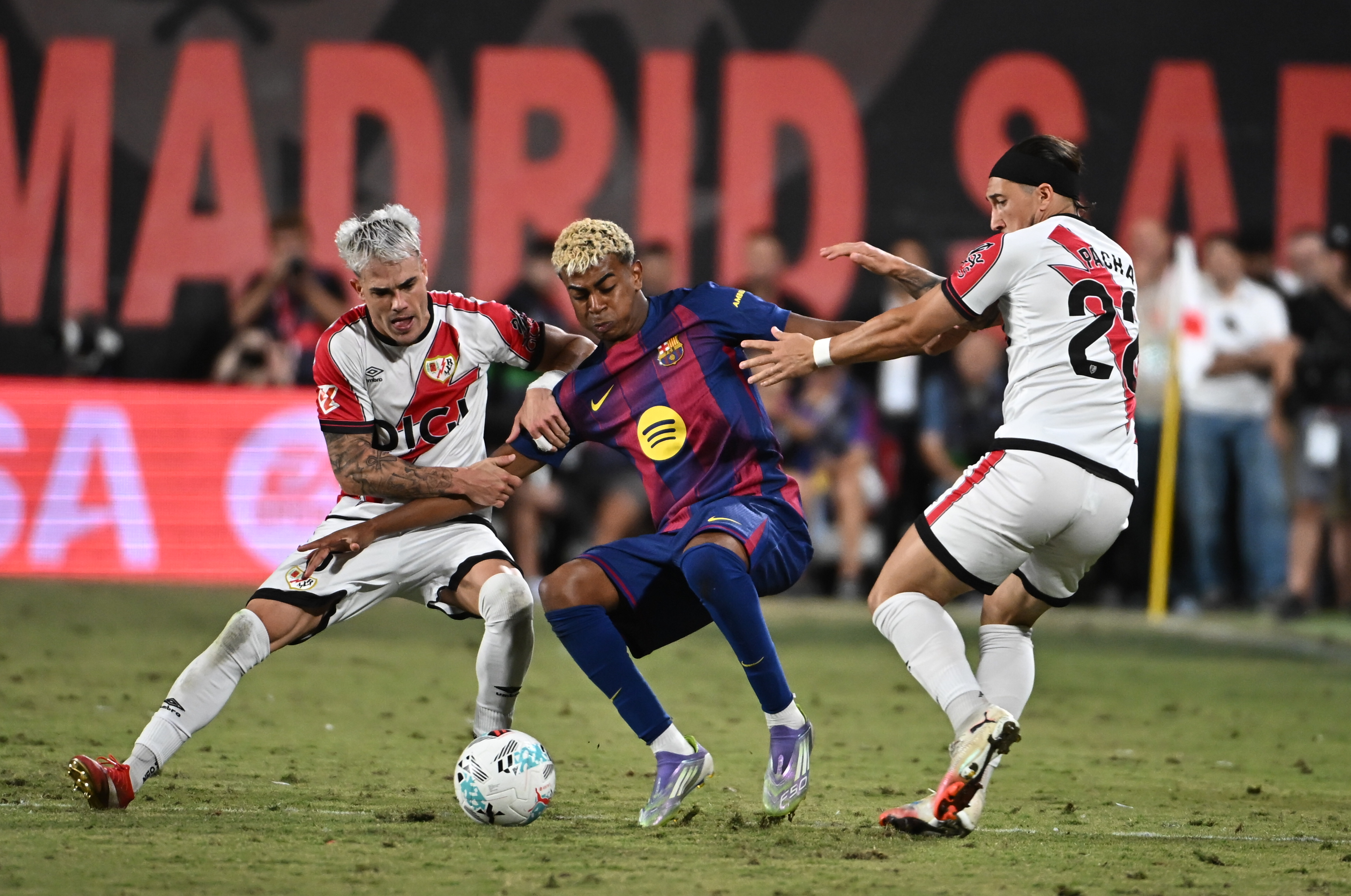 MADRID, 31/08/2025.- El defensa del Rayo Vallecano Josep Chavarría (i) lucha con Lamine Yamal (c), del FC Barcelona, durante el partido de la tercera jornada de LaLiga entre el Rayo Vallecano y el FC Barcelona, este domingo en el estadio de Vallecas. EFE/FERNANDO VILLAR