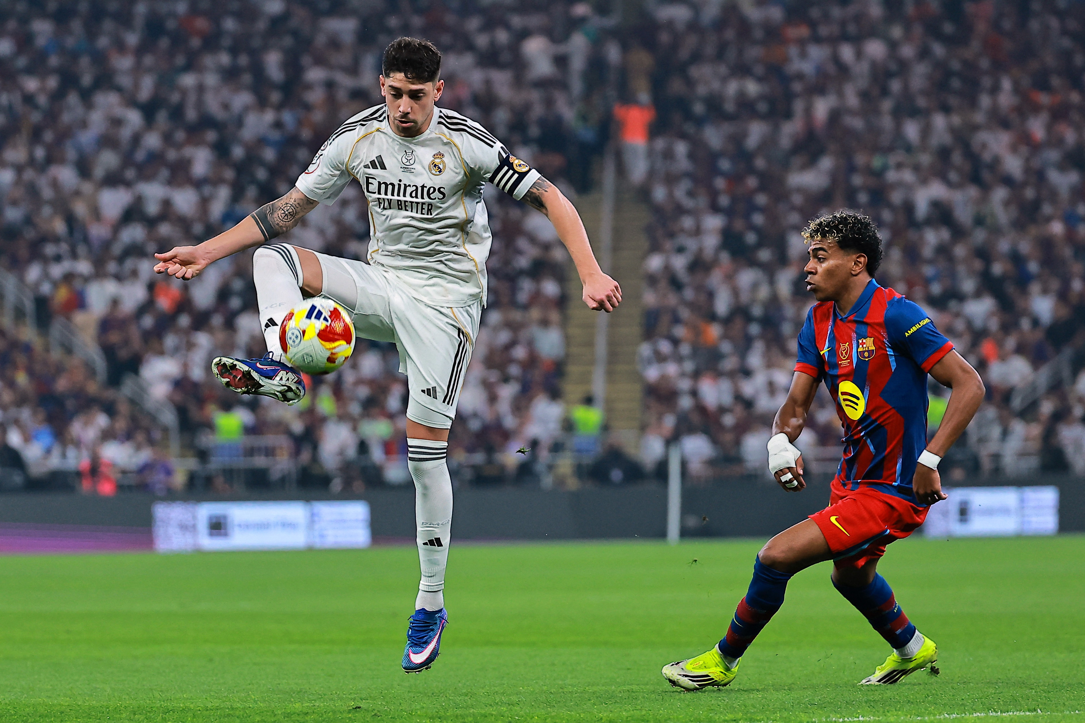 Soccer Football - Spanish Super Cup - Final - FC Barcelona v Real Madrid - King Abdullah Sports City Stadium, Jeddah, Saudi Arabia - January 11, 2026 FC Barcelona's Lamine Yamal in action with Real Madrid's Federico Valverde REUTERS/Stringer