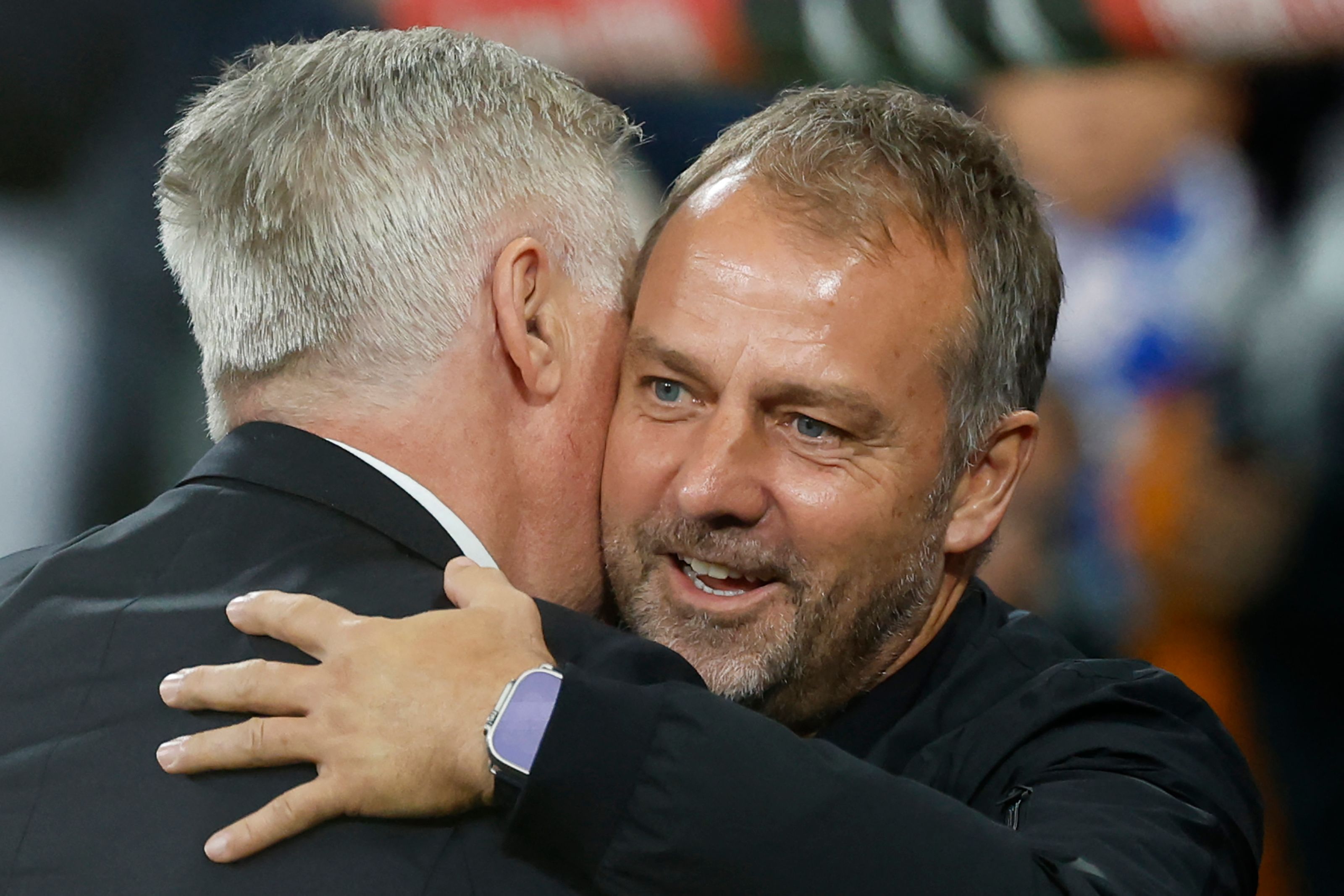 Real Madrid's Italian coach Carlo Ancelotti (L) and Barcelona's German coach Hans-Dieter Flick hug each other before the Spanish league football match between Real Madrid CF and FC Barcelona at the Santiago Bernabeu stadium in Madrid on October 26, 2024. (Photo by OSCAR DEL POZO / AFP)