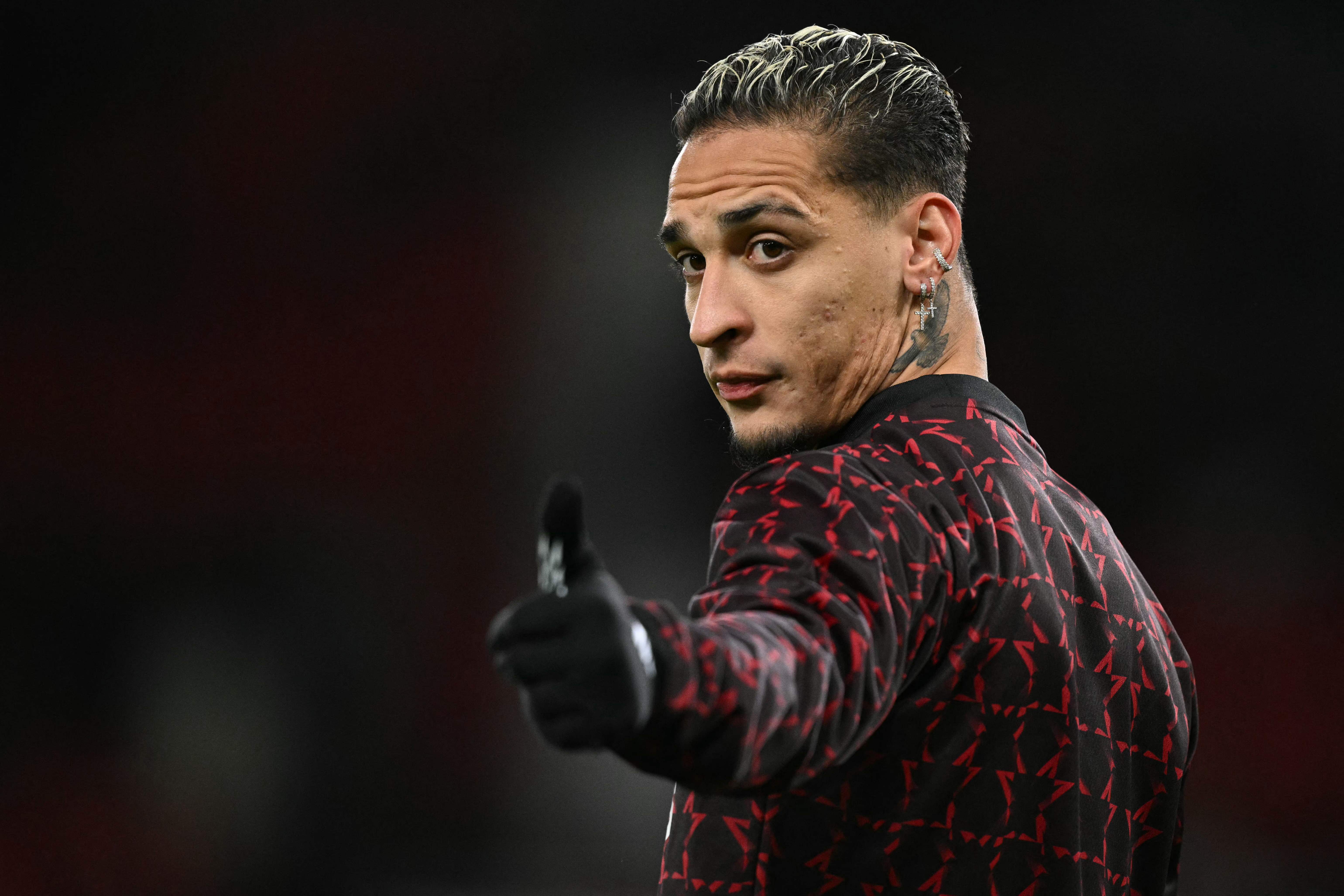 Manchester United's Brazilian midfielder #21 Antony warms up ahead of the UEFA Europa  League, League Phase football match between Manchester United and Bodoe/Glimt at Old Trafford stadium in Manchester, north west England, on November 28, 2024. (Photo by Oli SCARFF / AFP)