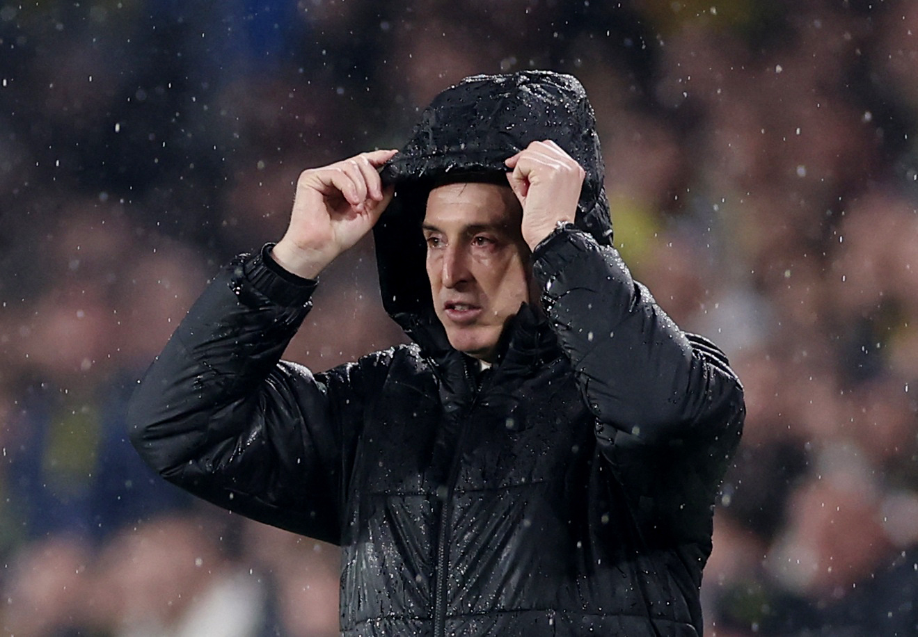 Soccer Football - UEFA Europa League - Fenerbahce v Aston Villa - Sukru Saracoglu Stadium, Istanbul, Turkey - January 22, 2026 Aston Villa manager Unai Emery uses his hood to shield himself from the rain REUTERS/Umit Bektas