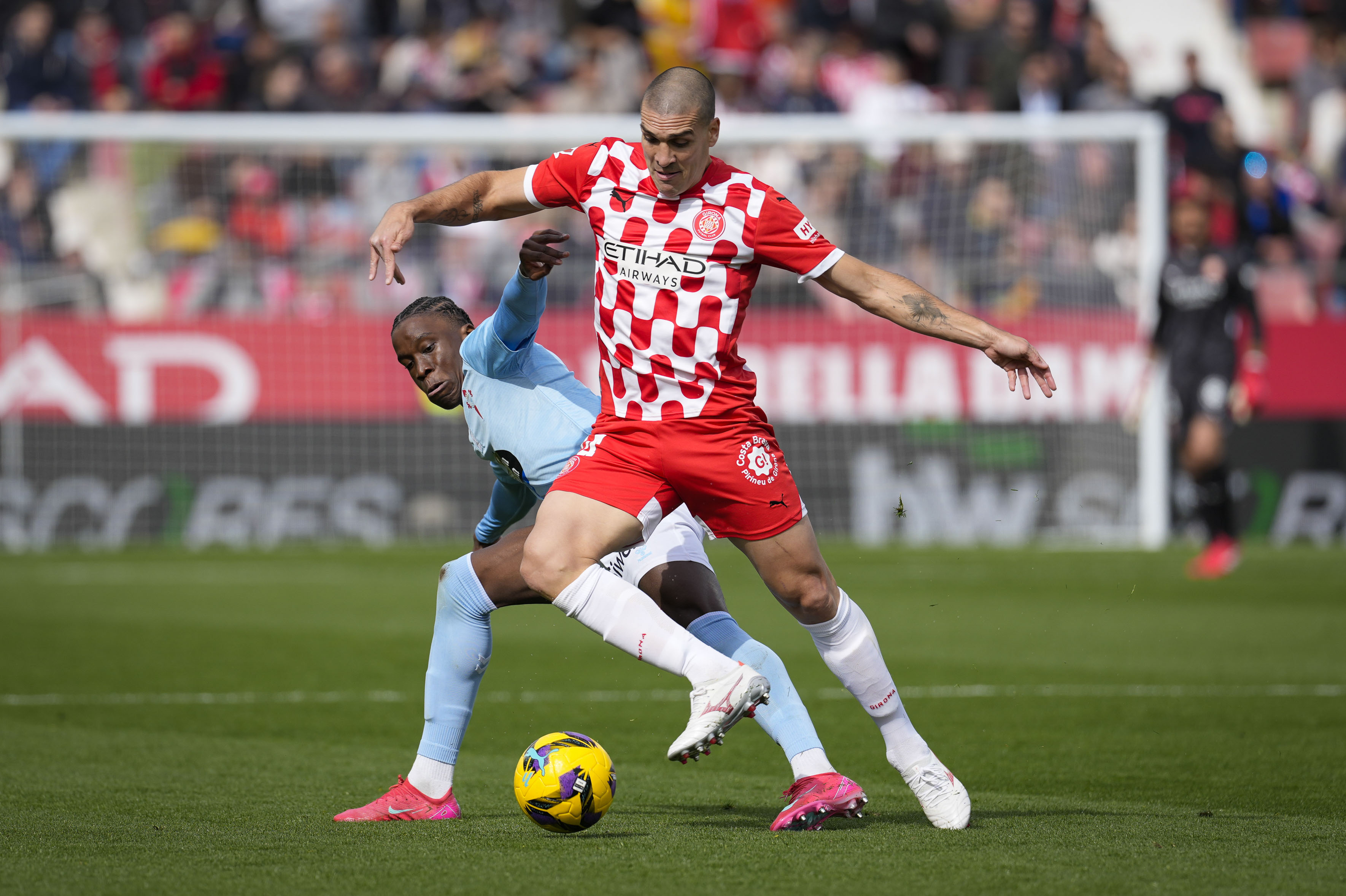 GIRONA, 01/03/2025.- El centrocampista del Celta Ilaix Moriba (izda) intenta impedir el avance de Oriol Romeu del Girona, durante encuentro que disputan en el estadio Montilivi este sábado, correspondiente a la jornada 26 de LaLiga. EFE/ David Borrrat