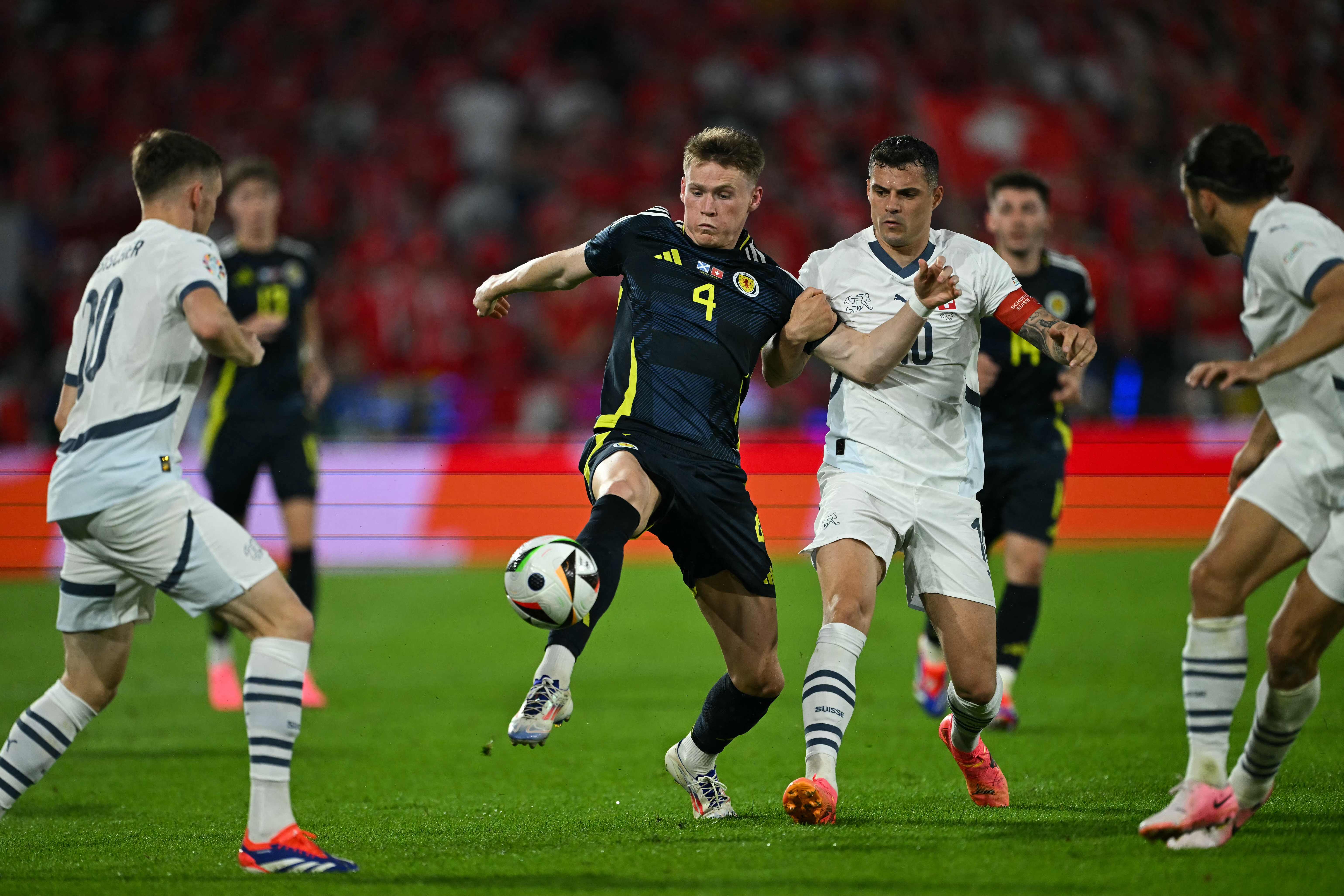 Switzerland's midfielder #10 Granit Xhaka fights for the ball with Scotland's midfielder #04 Scott McTominay during the UEFA Euro 2024 Group A football match between Scotland and Switzerland at the Cologne Stadium in Cologne on June 19, 2024. (Photo by OZAN KOSE / AFP)