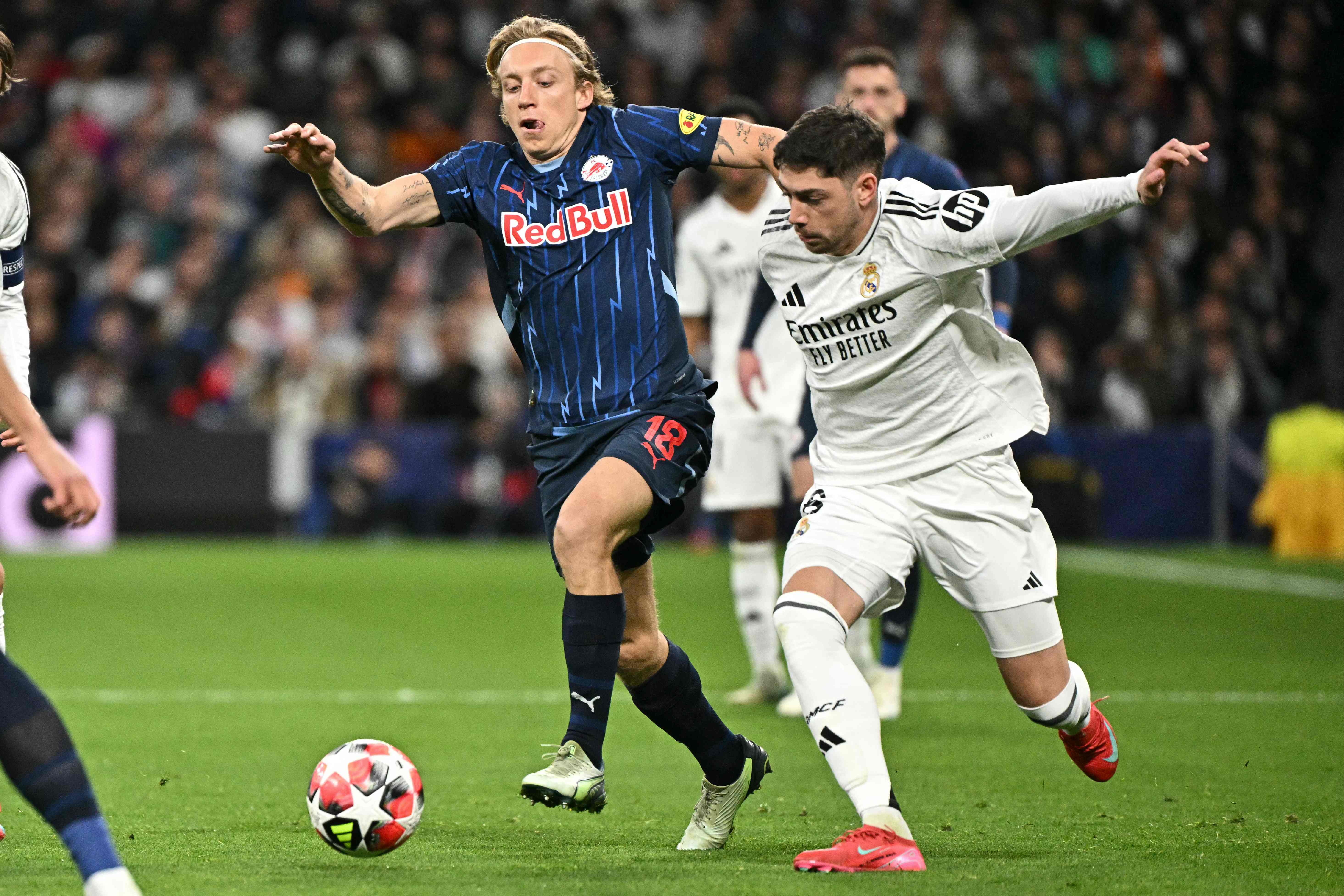 Salzburg's Danish midfielder #18 Mads Bidstrup (L) challenges Real Madrid's Uruguayan midfielder #08 Federico Valverde during the UEFA Champions League, league phase football match between Real Madrid CF and FC Salzburg at the Santiago Bernabeu stadium in Madrid on January 22, 2025. (Photo by JAVIER SORIANO / AFP)