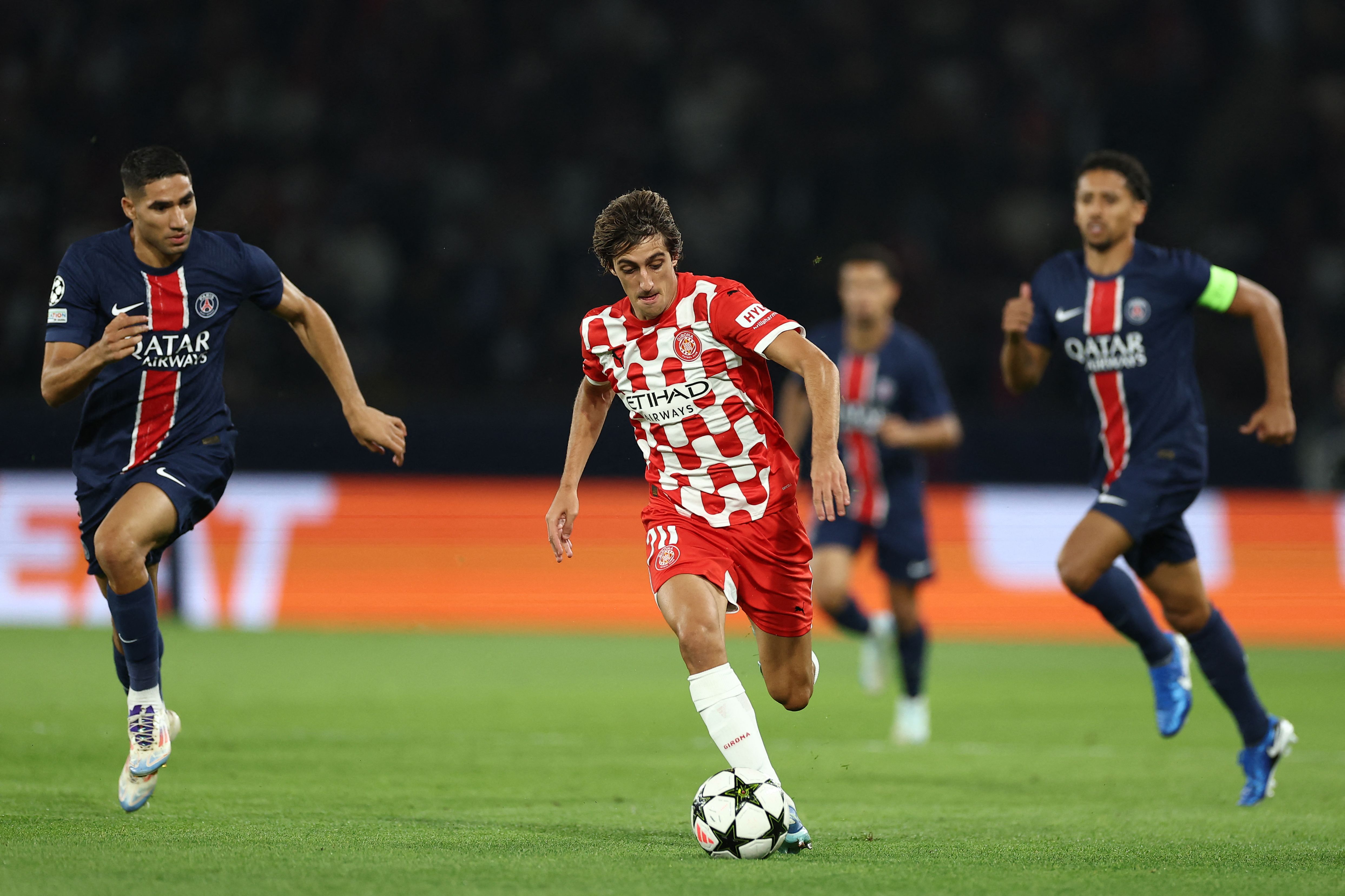 Girona's Spanish forward #20 Bryan Gil (C) runs with the ball ahead of Paris Saint-Germain's Moroccan midfielder #02 Achraf Hakimi (L) during the UEFA Champions League 1st round day 1 football match between Paris Saint-Germain (PSG) and Girona FC at the Parc des Princes Stadium, in Paris, on September 18, 2024. (Photo by FRANCK FIFE / AFP)