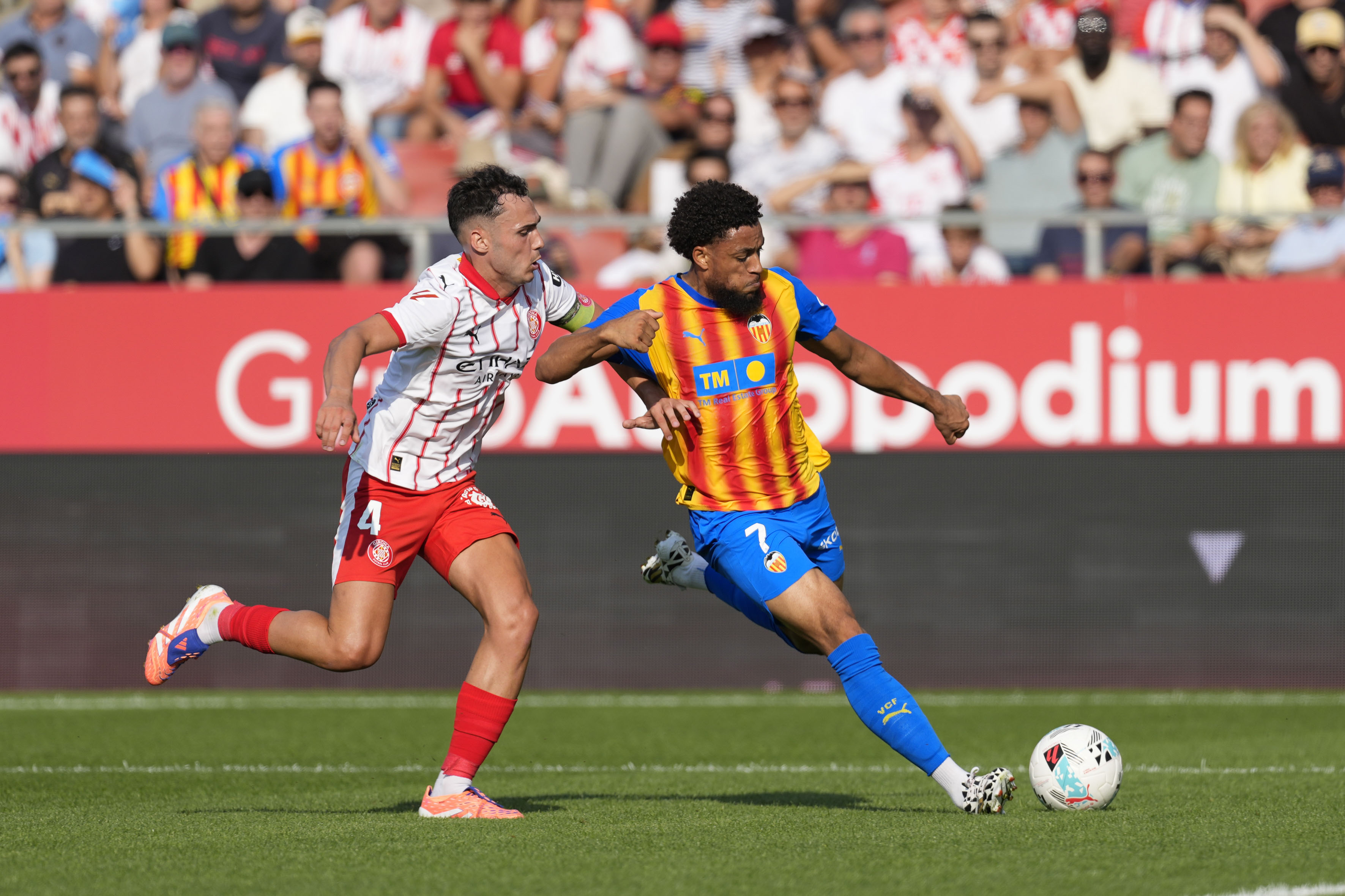 GIRONA, 04/10/2025.-El delantero del Valencia Arnaut Danjuma, y el centrocampista del Girona Arnau Martínez, durante el partido de la jornada 8 de la LaLiga EA Sports entre el Girona FC y el Valencia, este sábado en el estadio municipal de Montilivi.-EFE/ David Borrat