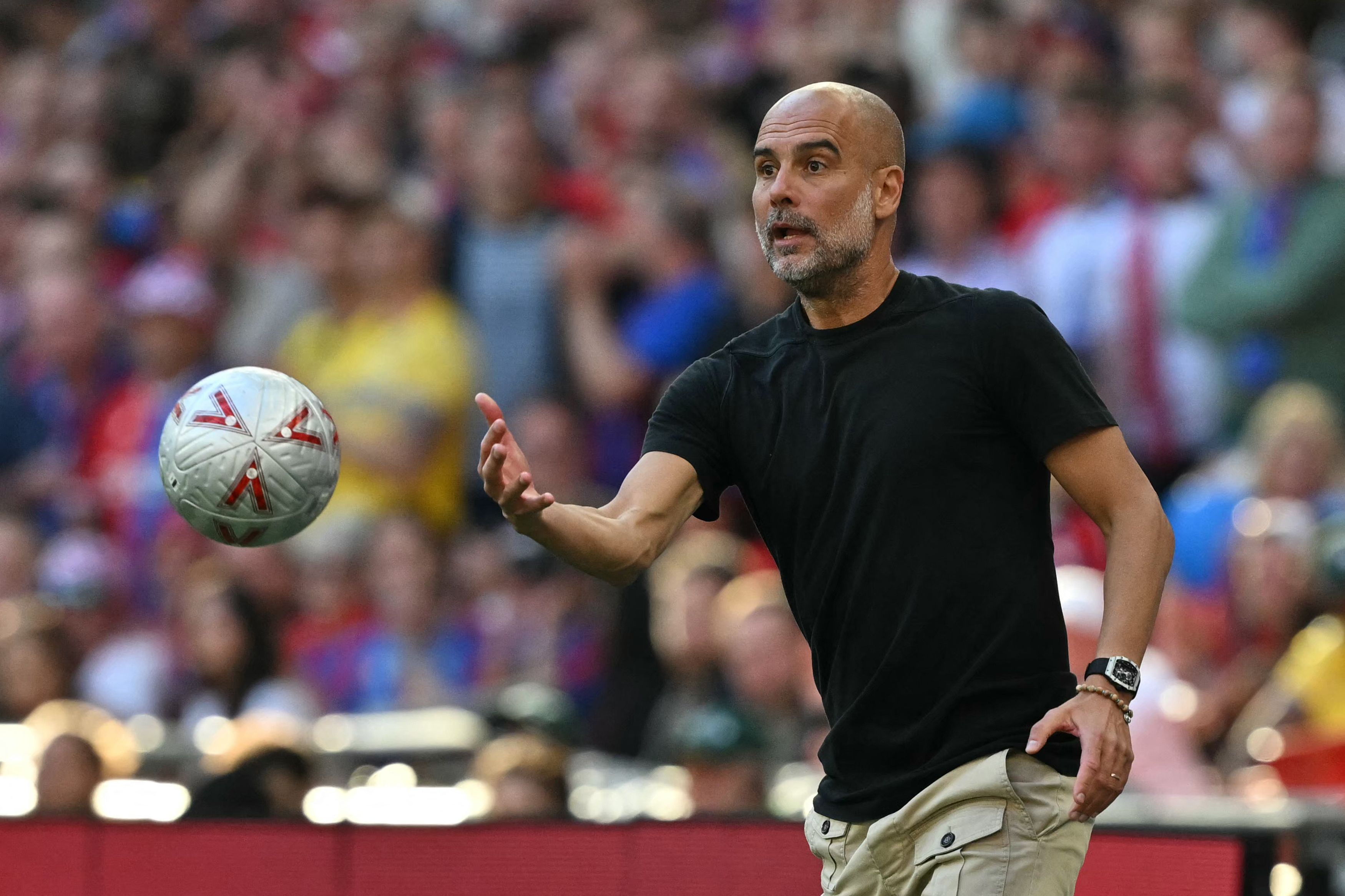 Manchester City's Spanish manager Pep Guardiola returns the ball during the English FA Cup final football match between Crystal Palace and Manchester City at Wembley stadium in London, on May 17, 2025. (Photo by Glyn KIRK / AFP) / NOT FOR MARKETING OR ADVERTISING USE / RESTRICTED TO EDITORIAL USE
