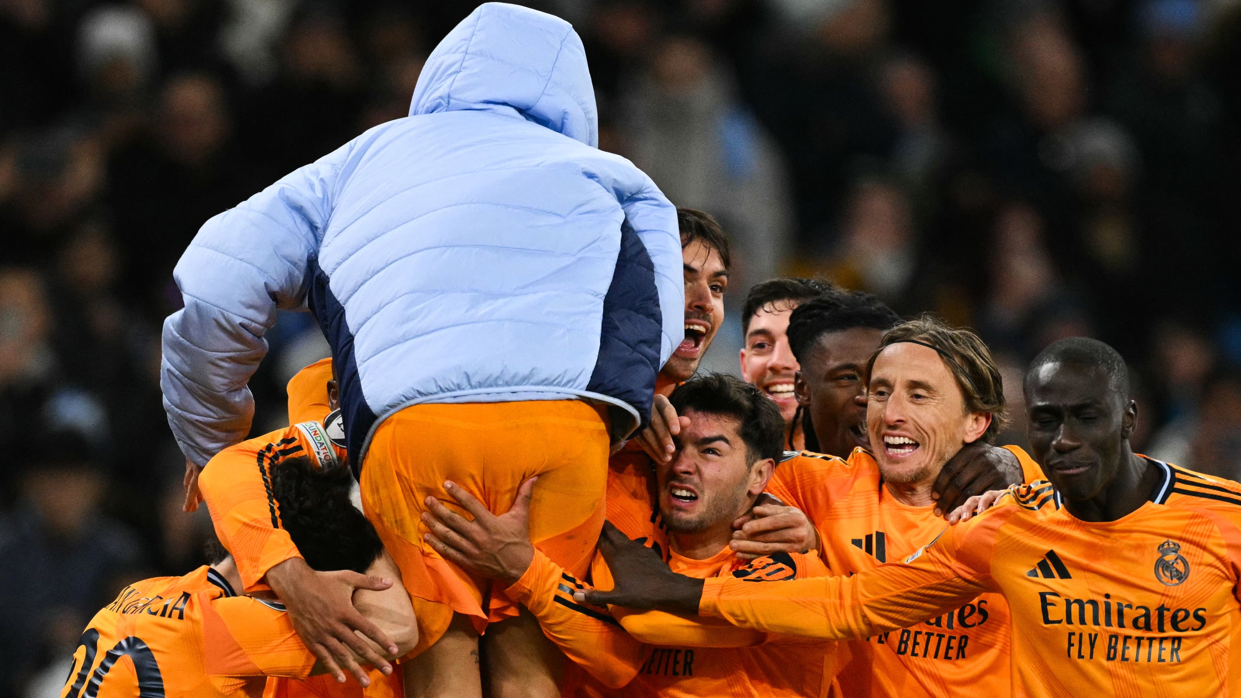 Real Madrid's English midfielder #05 Jude Bellingham celebrates with teammates after scoring his team third goal during the UEFA Champions League football match between Manchester City and Real Madrid at the Etihad Stadium in Manchester, north west England, on February 11, 2025. (Photo by Oli SCARFF / AFP)