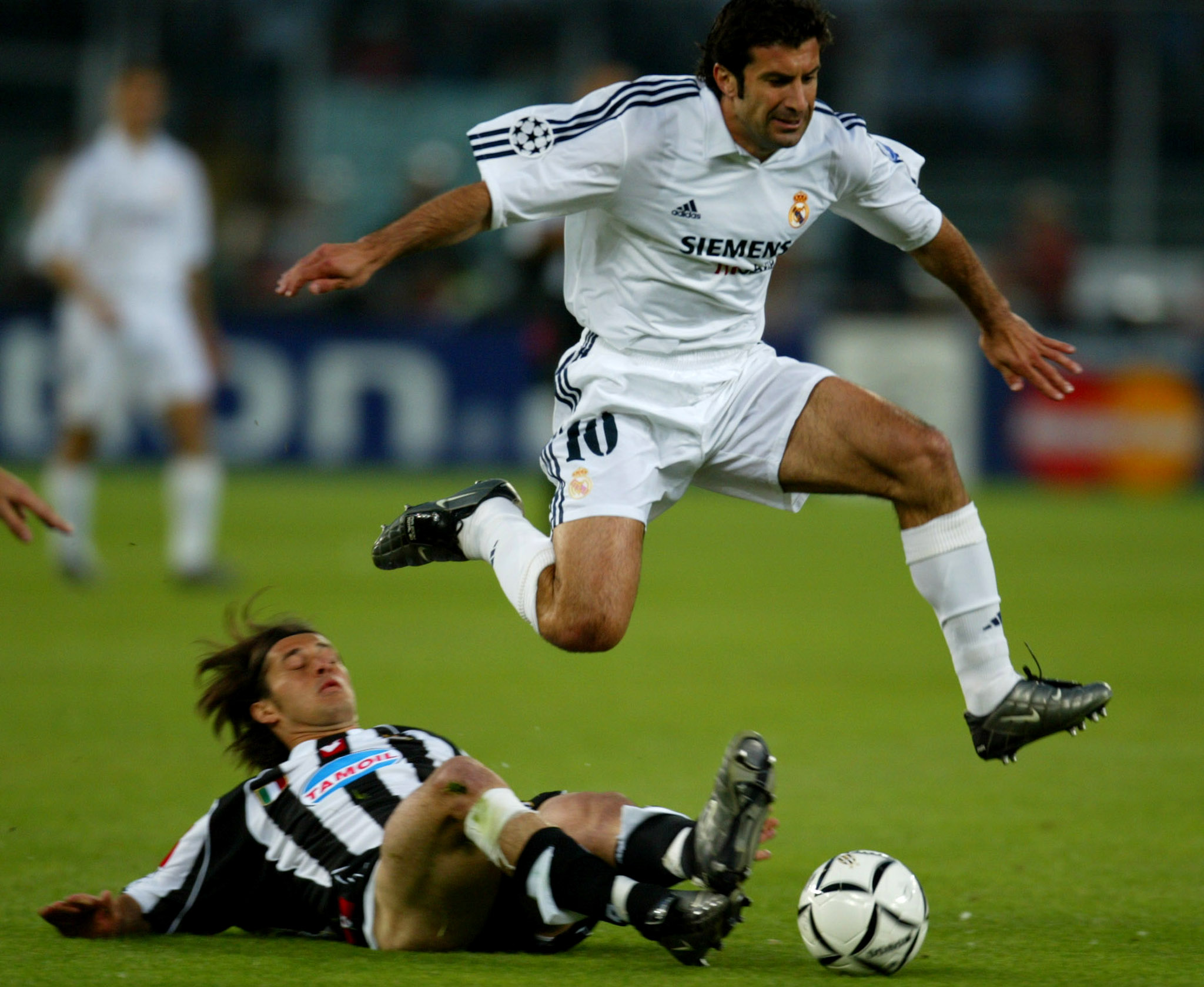 Real Madrid's Luis Figo (R) jumps over Juventus' Alessio Tacchinardi during the Champions League semi-final second leg match at the Delle Alpi in Turin May 14, 2003. REUTERS/Dylan Martinez REUTERS