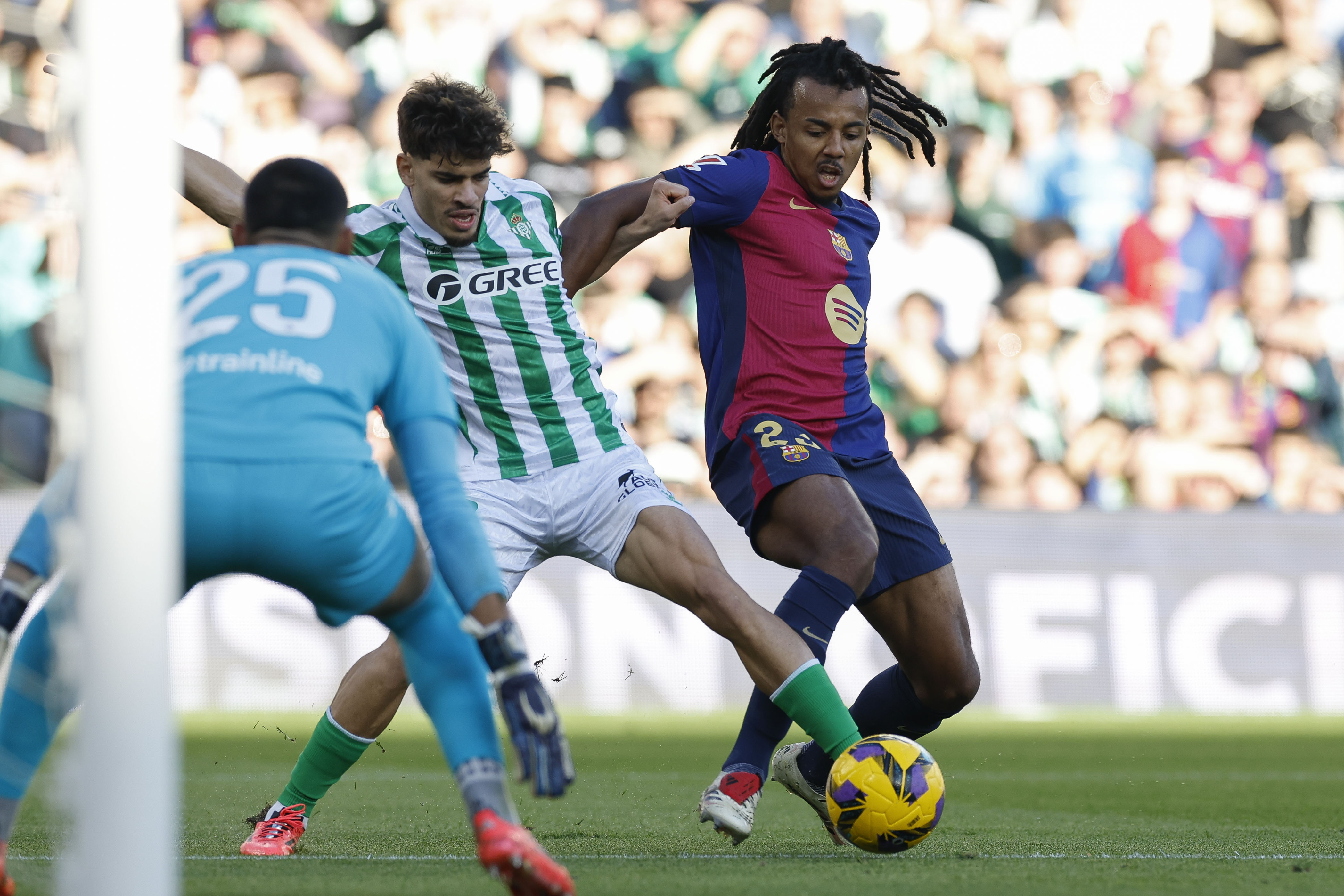 SEVILLA, 07/12/2024.- EL defensa francs del FC Barcelona Jules Kound (d) disputa un baln con el delantero hispano-marroqu del Betis Ez Abde (c) durante el partido de la jornada dcimo sexta de LaLiga EA Sports que disputan este sbado Real Betis Balompi y FC Barcelona en el Estadio Benito Villamarn de Sevilla. EFE/ Julio Mu?oz
