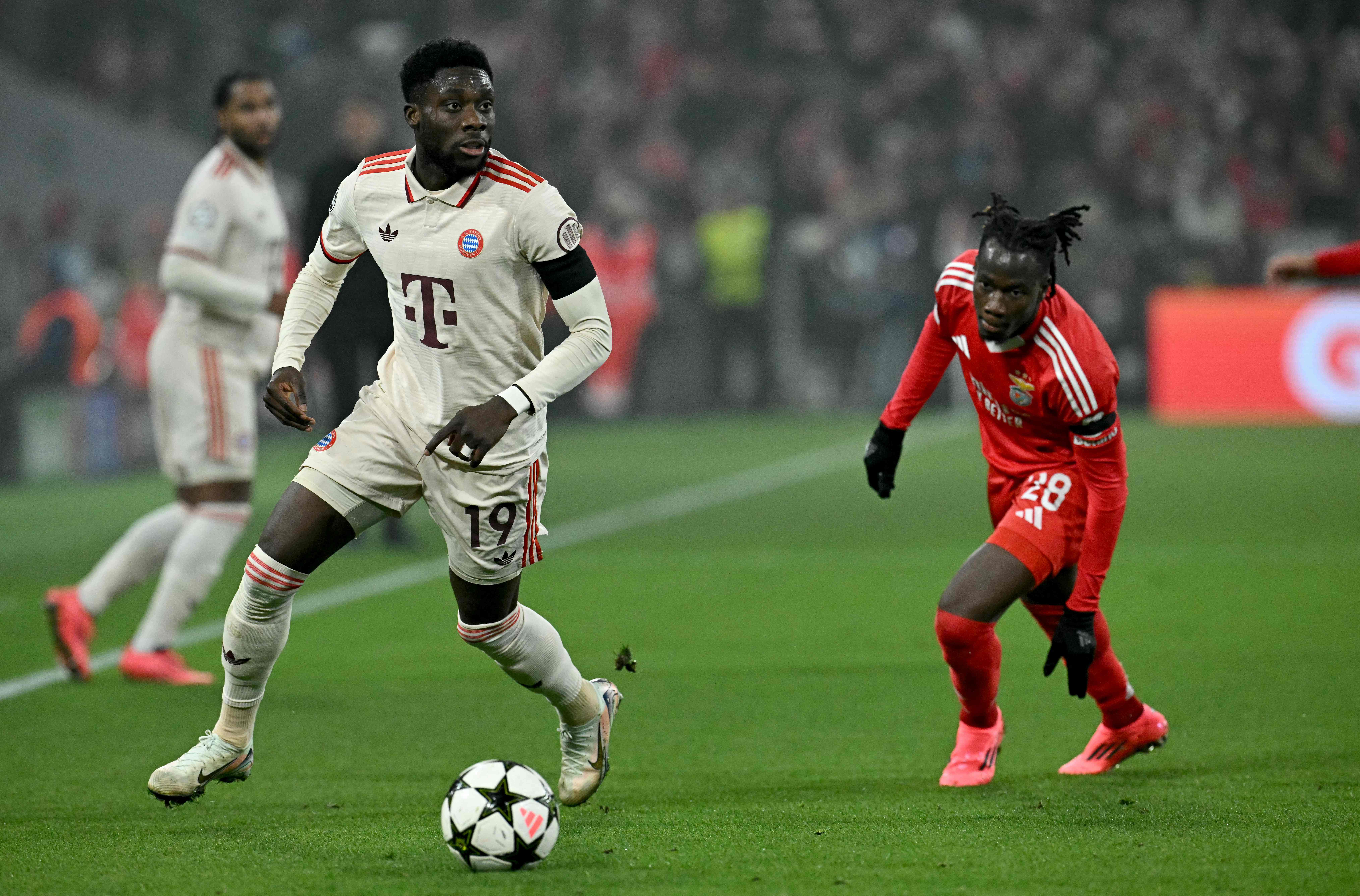 Bayern Munich's Canadian defender #19 Alphonso Davies (L) and Benfica's Burkinabe defender #28 Issa Kabore vie for the ball during the UEFA Champions League football match FC Bayern Munich vs SL Benfica in Munich, southern Germany, on November 6, 2024. (Photo by Tobias SCHWARZ / AFP)