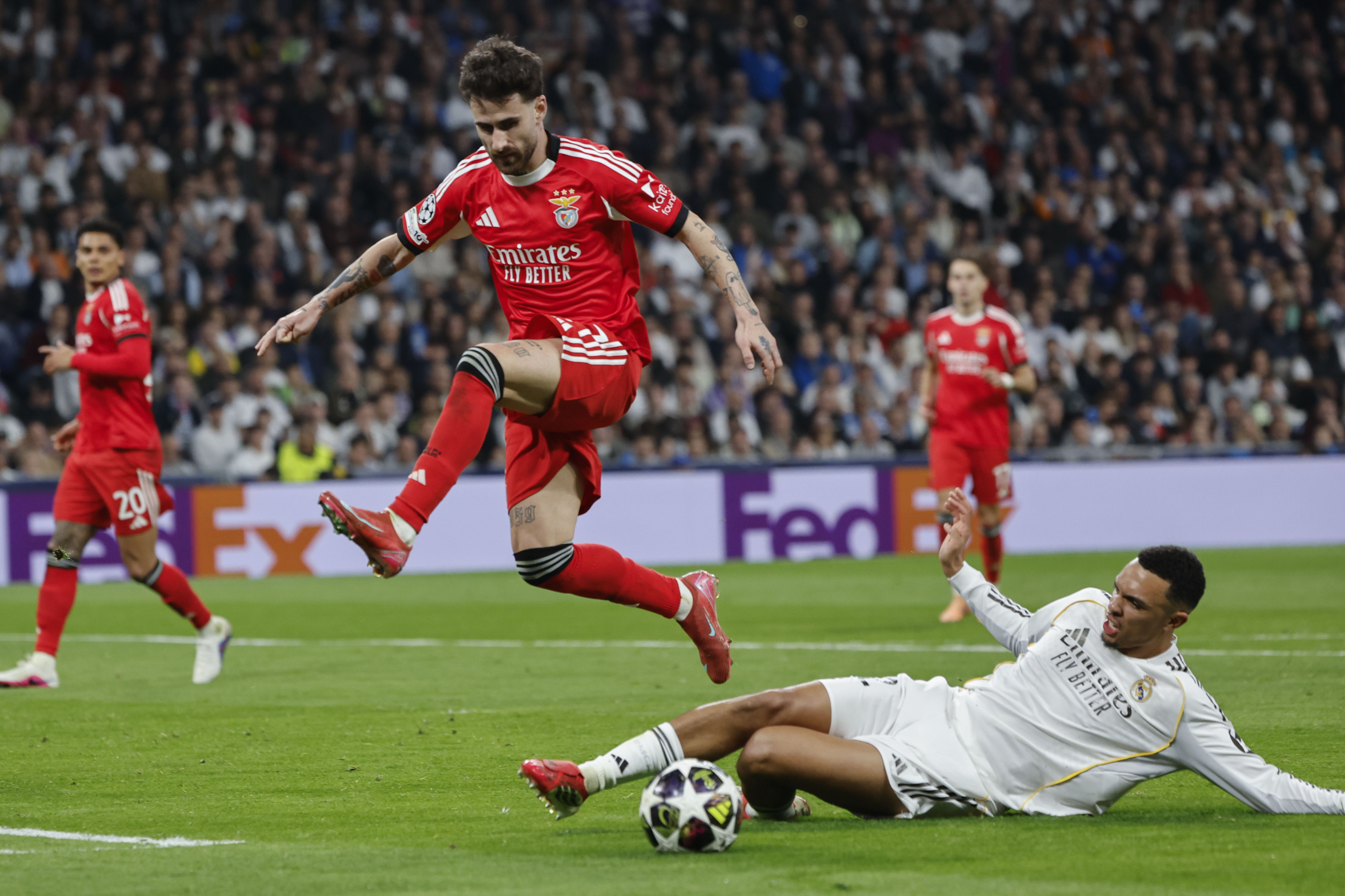 MADRID, 25/02/2026.- EL centrocampista del Benfica Rafa Silva (i) pelea un balón con el defensa inglés del Real Madrid Trent Alexander Arnold durante el partido de vuelta de la fase de acceso a los octavos de la Liga de Campeones que Real Madrid y Benfica disputan este miércoles en el estadio Santiago Bernabéu, en Madrid. EFE/ Sergio Pérez
