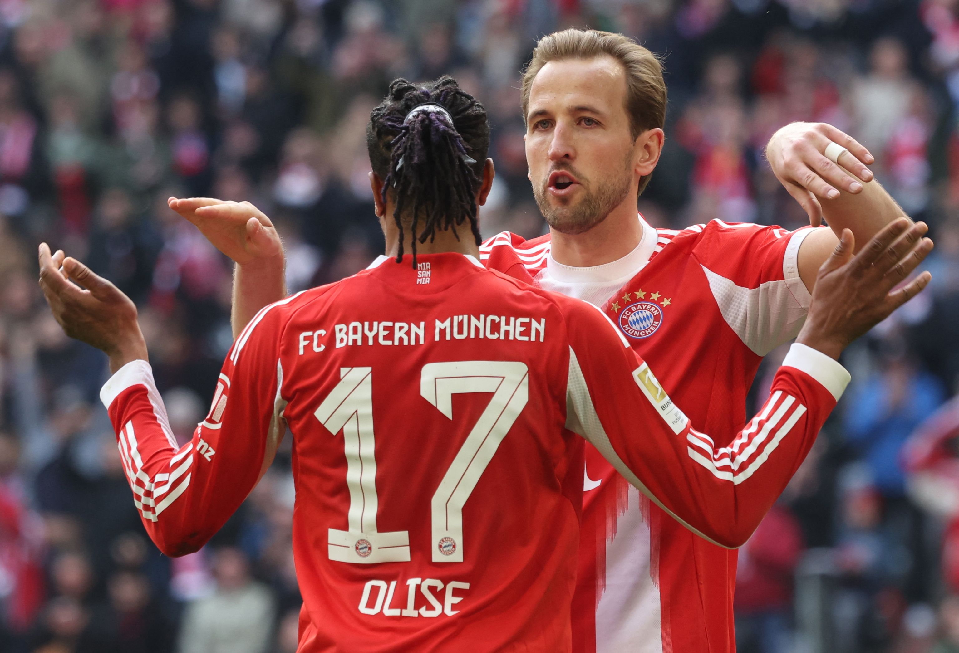 Bayern Munich's French midfielder #17 Michael Olise celebrates his 1-0 with Bayern Munich's English forward #09 Harry Kane during the German first division Bundesliga football match between FC Bayern Munich and Union Berlin in Munich, southern Germany, on March 21, 2026. (Photo by Karl-Josef HILDENBRAND / AFP) / DFL REGULATIONS PROHIBIT ANY USE OF PHOTOGRAPHS AS IMAGE SEQUENCES AND/OR QUASI-VIDEO