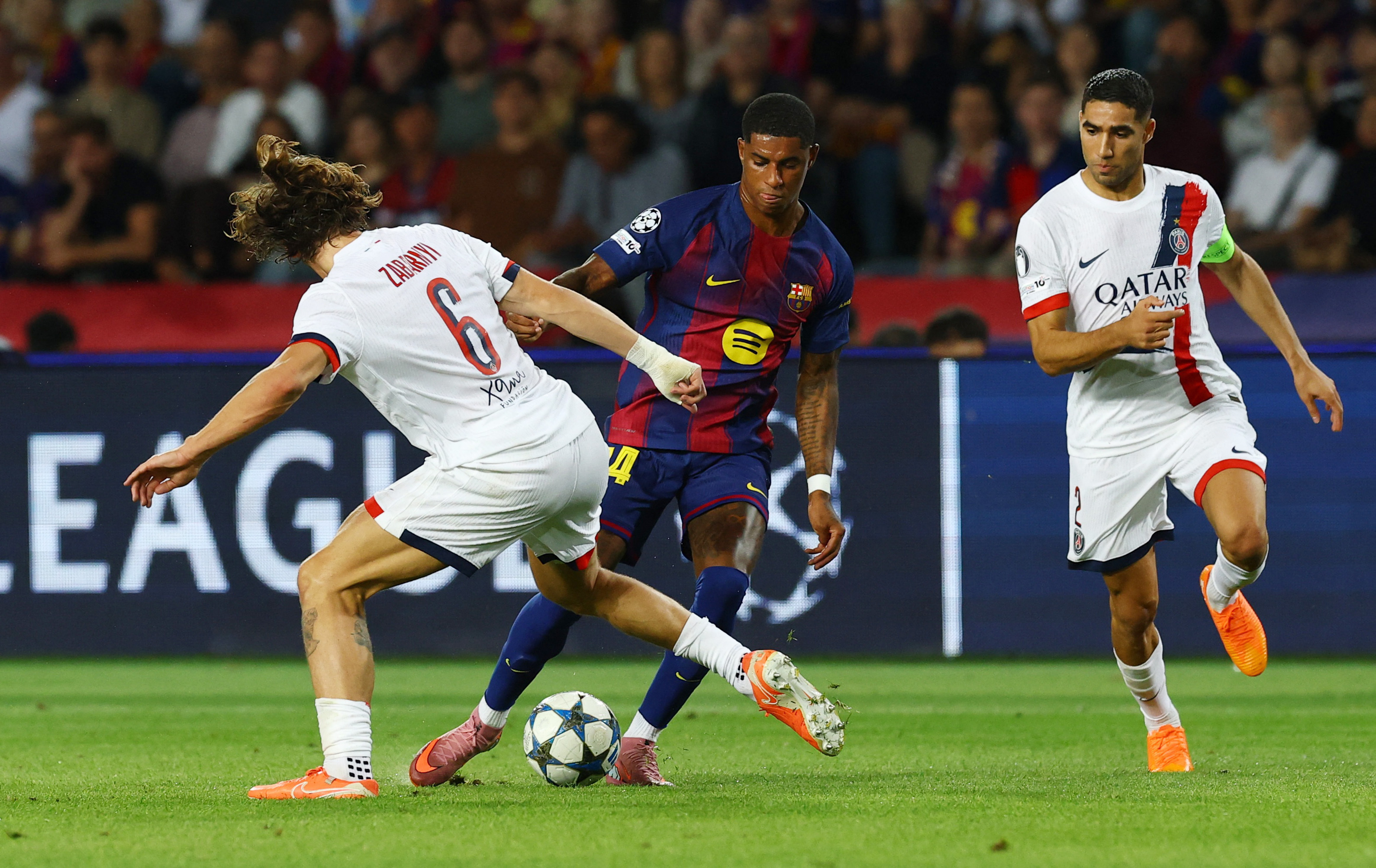 Soccer Football - UEFA Champions League - FC Barcelona v Paris St Germain - Estadi Olimpic Lluis Companys, Barcelona, Spain - October 1, 2025 FC Barcelona's Marcus Rashford in action with Paris St Germain's Illia Zabarnyi REUTERS/Albert Gea
