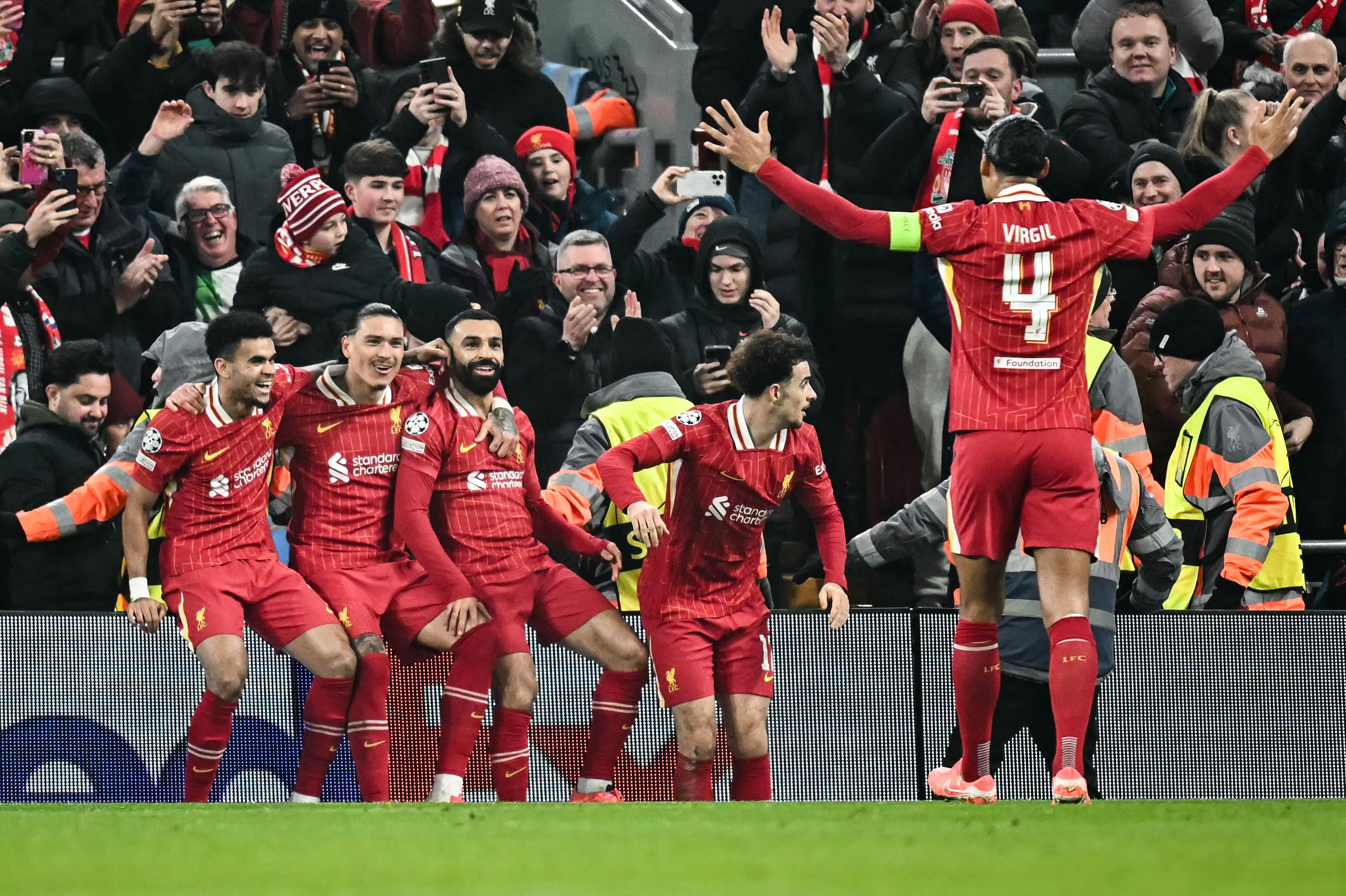 Liverpool's Egyptian striker #11 Mohamed Salah (C) celebrates with teammates after scoring his team first goal during the UEFA Champions League football match between Liverpool and Lille LOSC at Anfield in Liverpool, north west England on January 21, 2025. (Photo by Paul ELLIS / AFP)