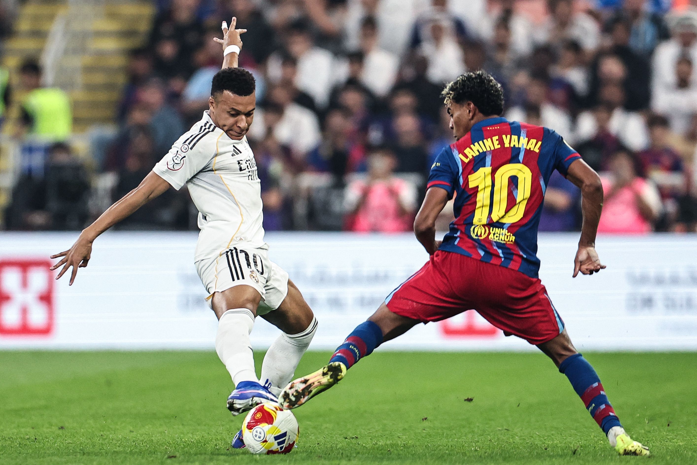Real Madrid's French forward #10 Kylian Mbappe (L) and Barcelona's Spanish forward #10 Lamine Yamal fight for the ball during the Spanish Super Cup final football match between FC Barcelona and Real Madrid at the King Abdullah Stadium�in Jeddah on January 11, 2026. (Photo by Fadel SENNA / AFP)