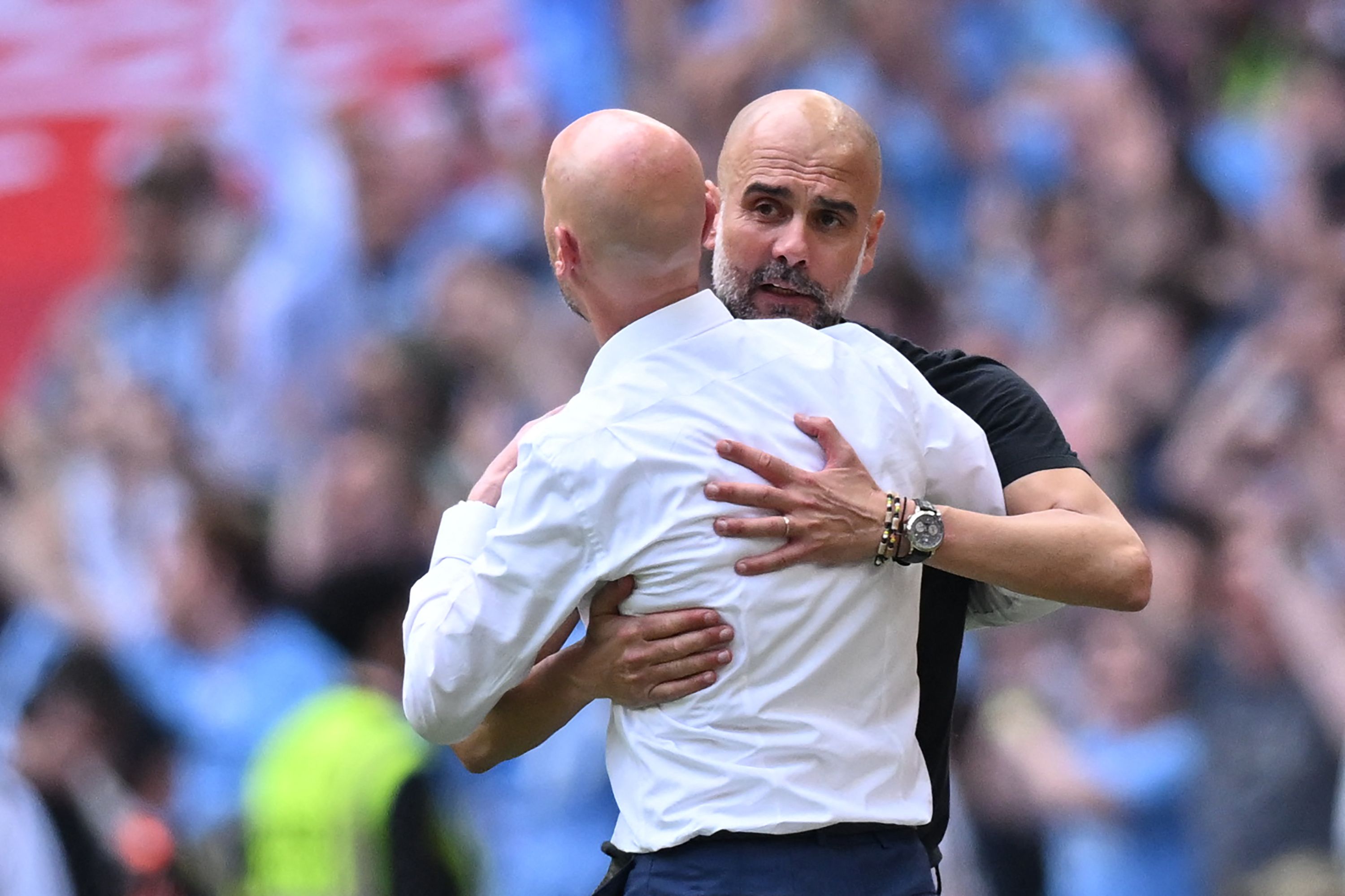 Manchester United's Dutch manager Erik ten Hag (L) and Manchester City's Spanish manager Pep Guardiola embrace on the final whistle of the English FA Cup final football match between Manchester City and Manchester United at Wembley stadium, in London, on June 3, 2023. Man City won the game 2-1. (Photo by Glyn KIRK / AFP) / NOT FOR MARKETING OR ADVERTISING USE / RESTRICTED TO EDITORIAL USE