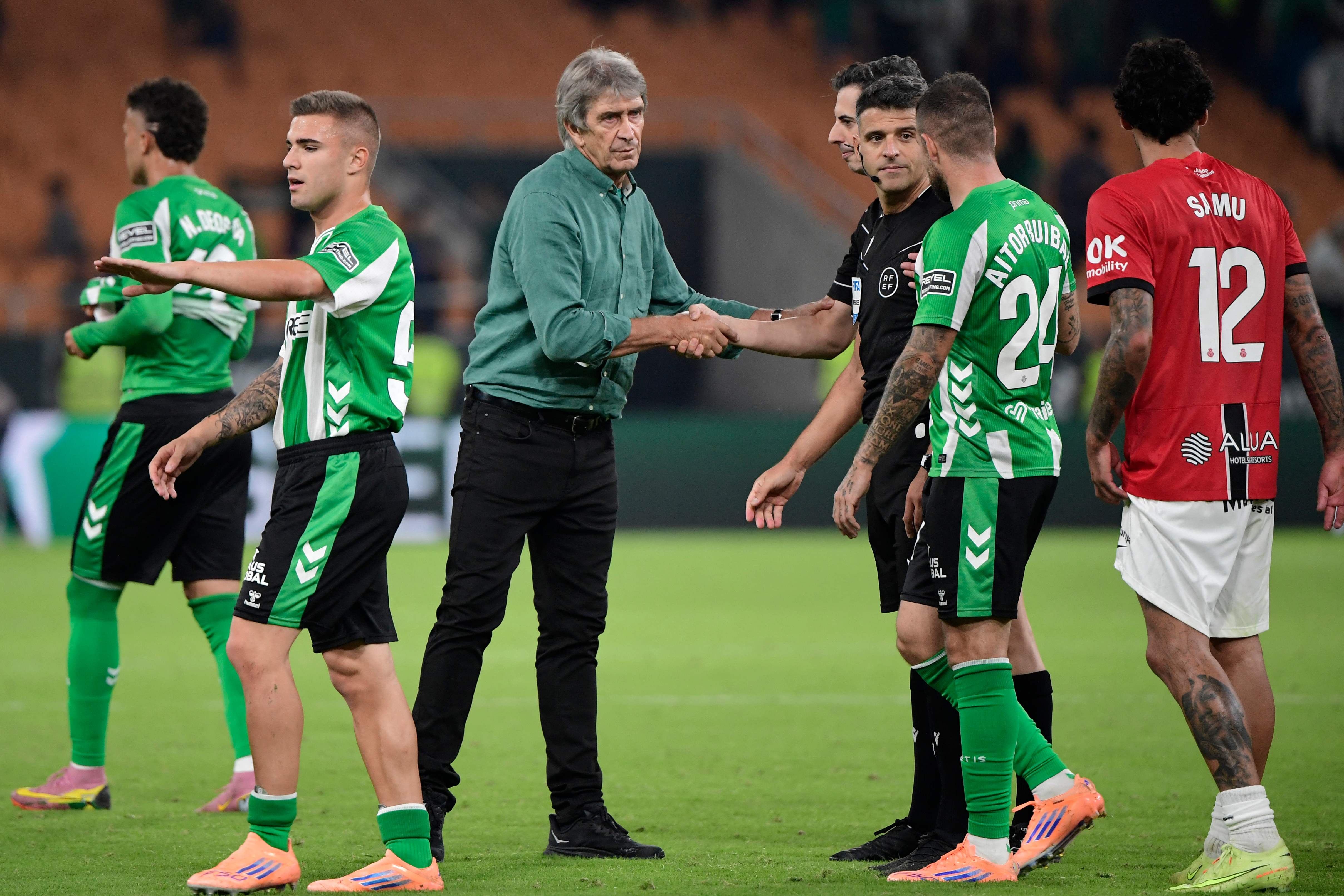 Real Betis' Chilean coach Manuel Pellegrini shakes hands with the referees at the end of the Spanish league football match between Real Betis and RCD Mallorca at Benito Villamarin Stadium in Seville on November 2, 2025. (Photo by CRISTINA QUICLER / AFP)