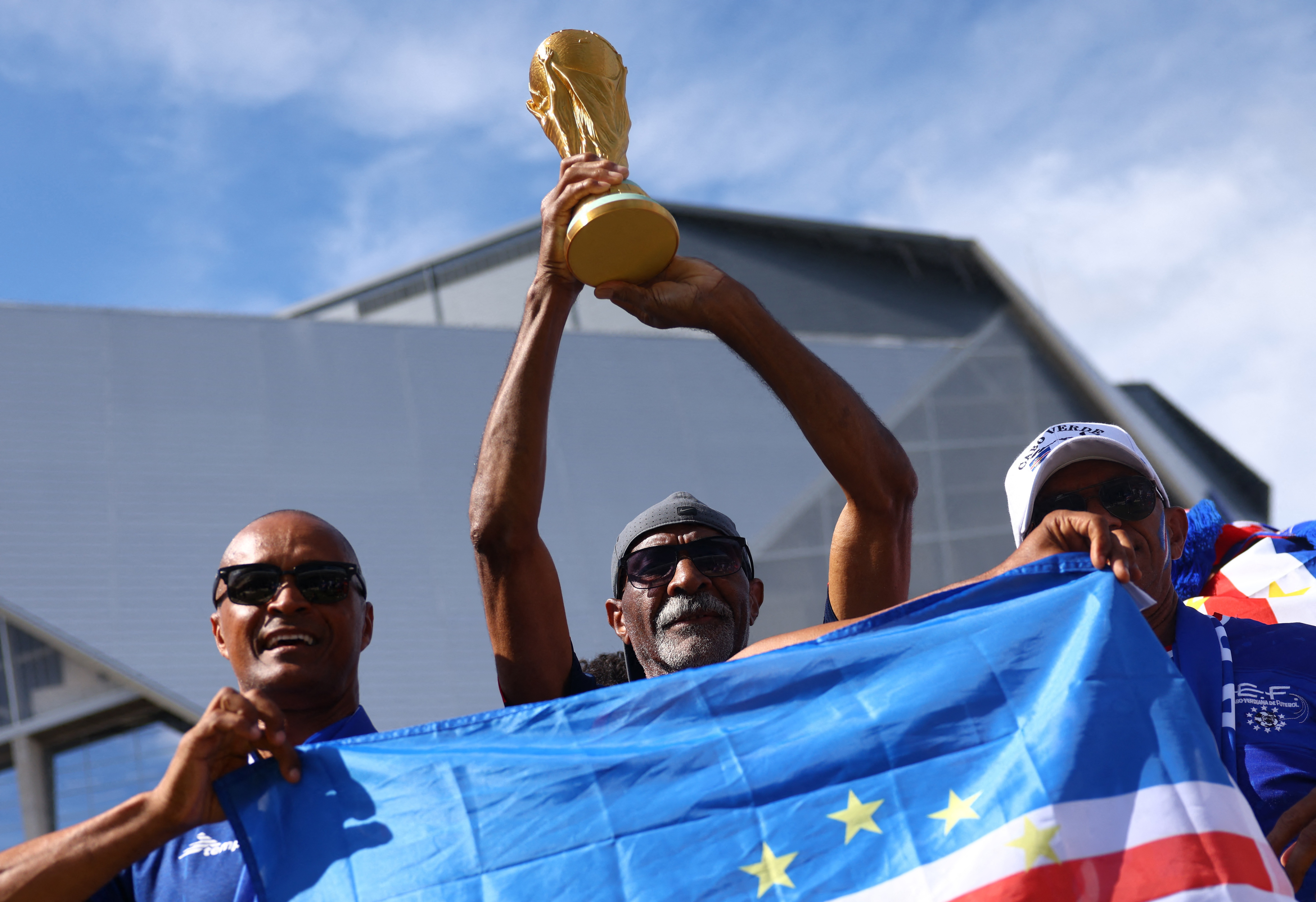 Soccer Football - FIFA World Cup 2026 - Group H - Spain v Cape Verde - Atlanta Stadium, Atlanta, Georgia, U.S. - June 15, 2026 Cape Verde fans display a replica World Cup trophy and a flag outside the stadium before the match REUTERS/Claudia Greco