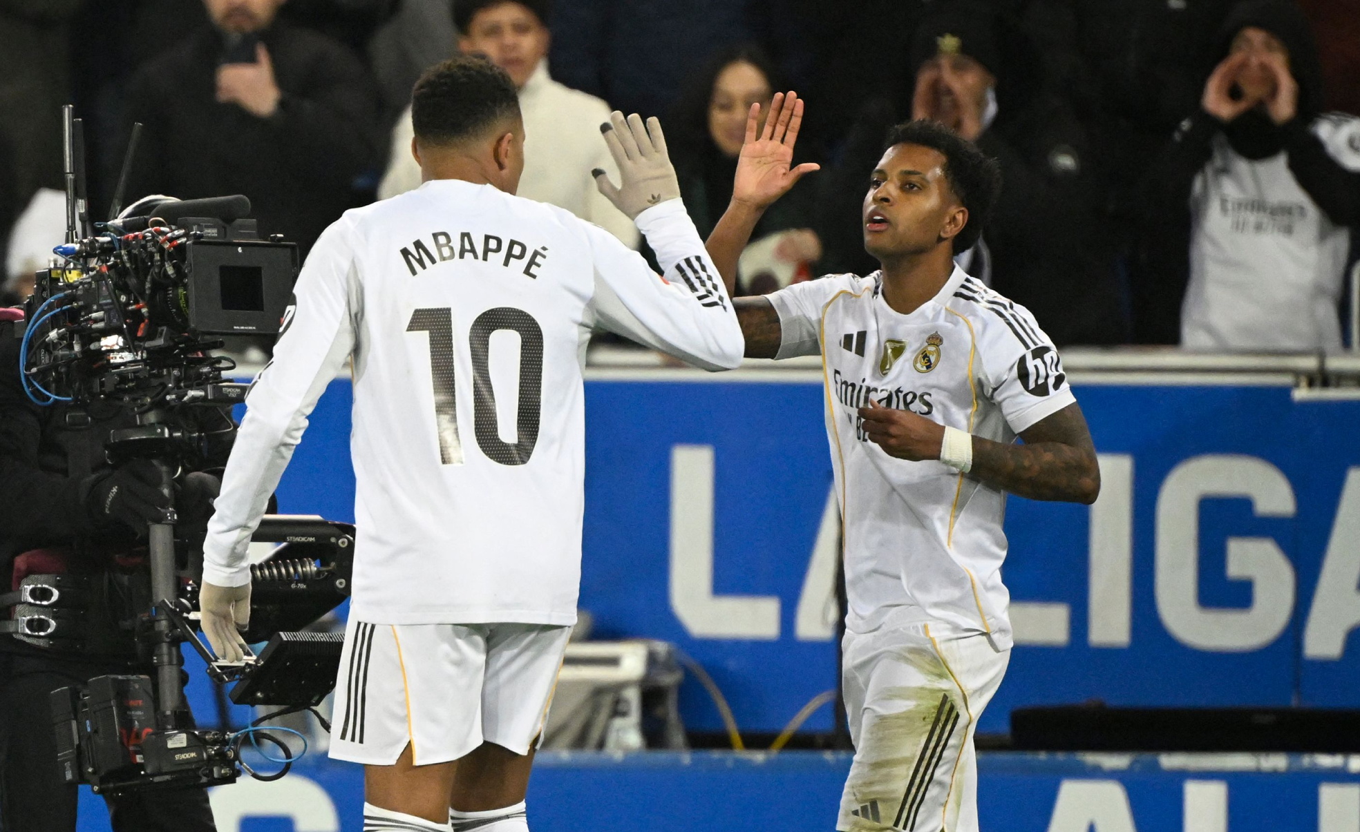 Real Madrid's Brazilian forward #11 Rodrygo celebrates scoring his team's second goal with Real Madrid's French forward #10 Kylian Mbappe during the Spanish league football match between Deportivo Alaves and Real Madrid CF at the Mendizorroza stadium in Vitoria on December 14, 2025. (Photo by ANDER GILLENEA / AFP)