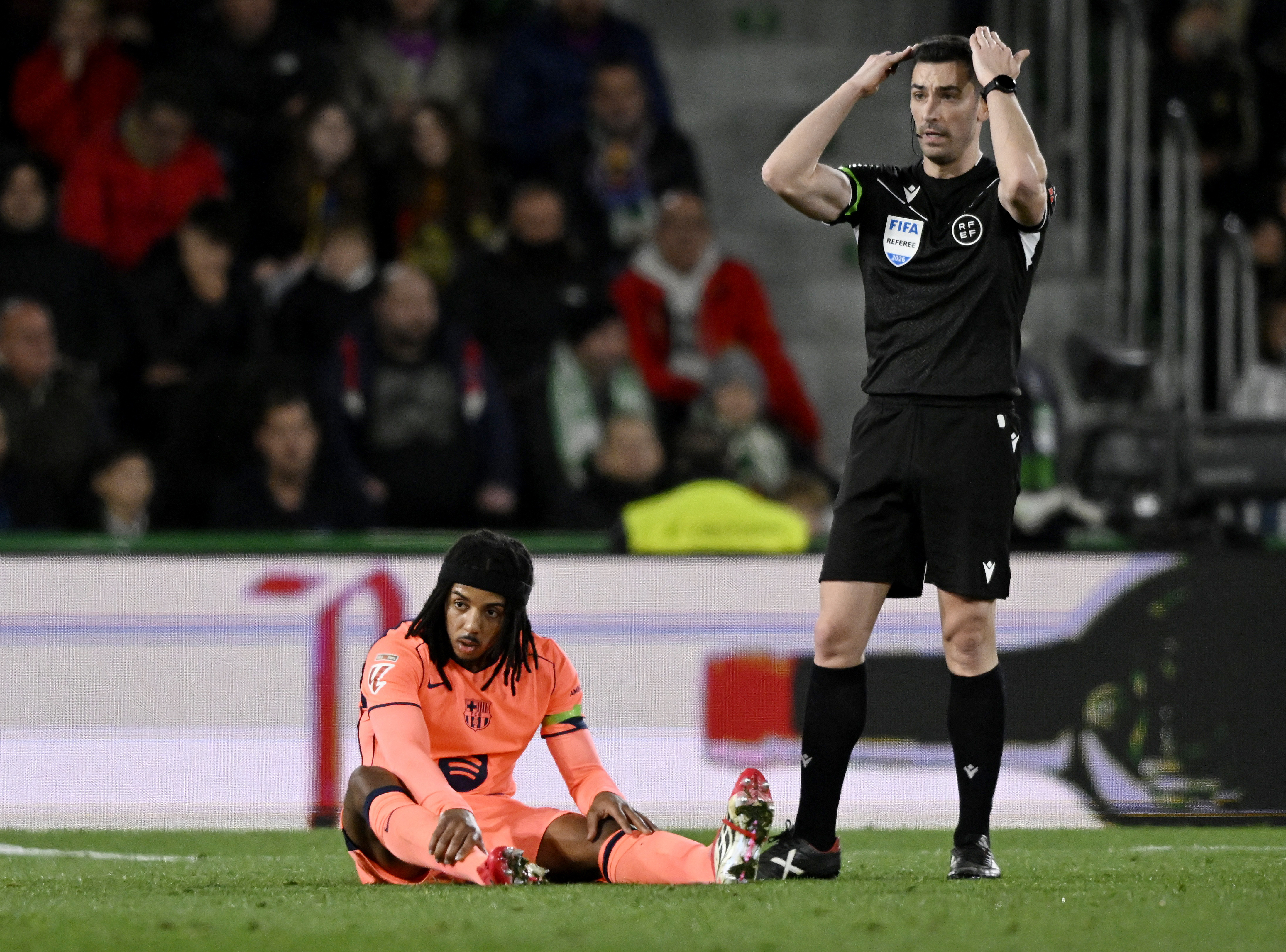 Soccer Football - LaLiga - Elche v FC Barcelona - Estadio Manuel Martinez Valero, Elche, Spain - January 31, 2026 FC Barcelona's Jules Kounde reacts after sustaining an injury as referee Alejandro Ruiz looks on REUTERS/Pablo Morano
