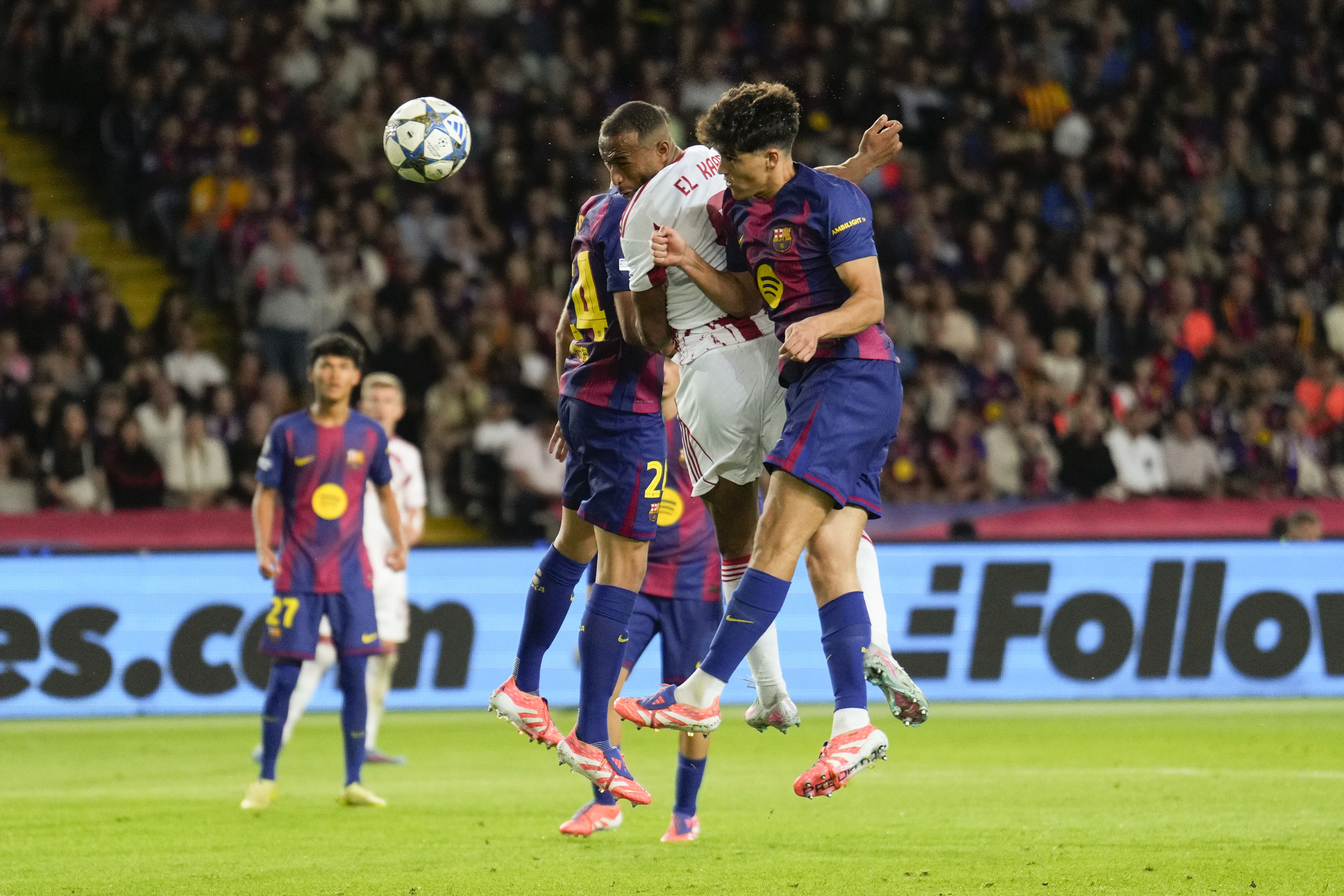 BARCELONA, 21/10/2025.- El delantero de Olympiacos Ayoub El Kaabi (c) marca entre Pau Cubarsí (d) y Eric García, ambos del Barcelona, durante el partido de la tercera jornada de la Liga de Campeones que FC Barcelona y Olympiacos FC disputan este martes en el Estadio Olímpico Lluís Companys. EFE/Alejandro García
