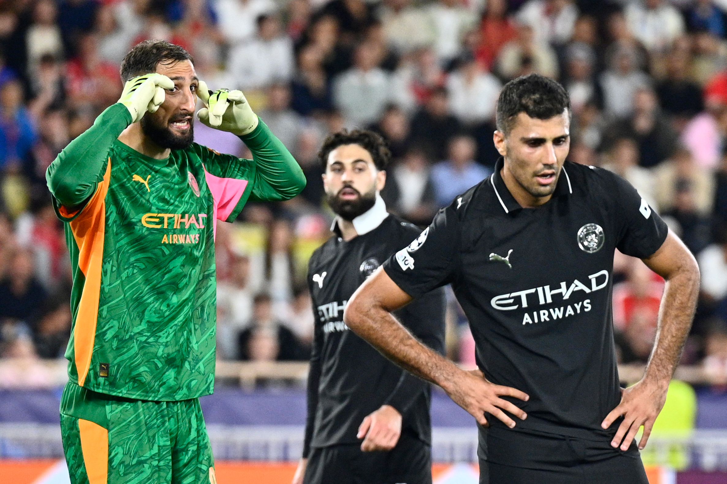 Manchester City's Italian goalkeeper #25 Gianluigi Donnarumma (L) gestures next to Manchester City's Spanish midfielder #16 Rodri during the UEFA Champions League, league phase day 2, football match between Monaco and Manchester City at Stade Louis II, in Monaco on October 1, 2025. (Photo by Frederic Dides / AFP)