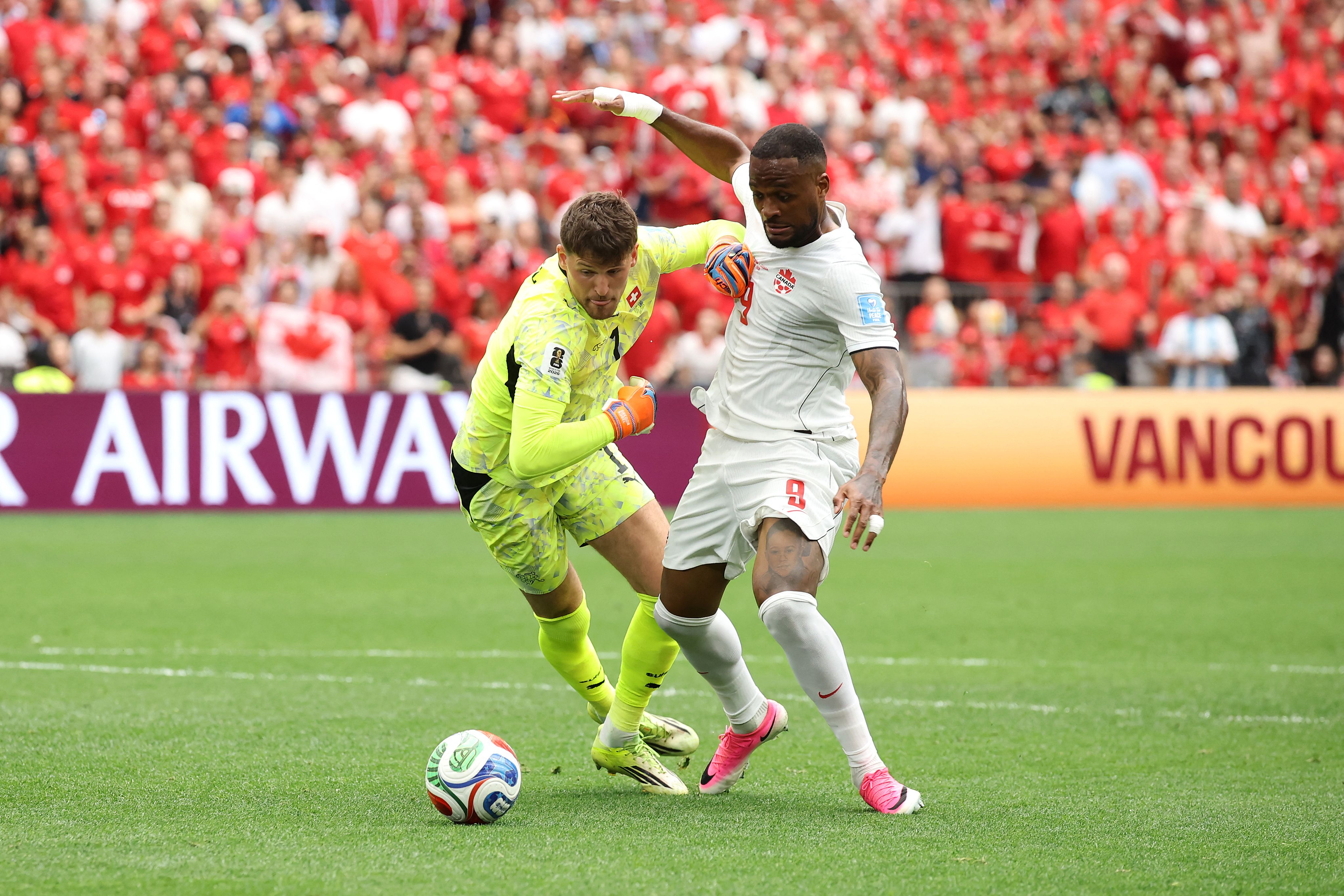 VANCOUVER, BRITISH COLUMBIA - JUNE 24: Gregor Kobel #1 of Switzerland blocks Cyle Larin #9 of Canada during the FIFA World Cup 2026 Group B match between Switzerland and Canada at BC Place Vancouver on June 24, 2026 in Vancouver, British Columbia.   Alex Grimm/Getty Images/AFP (Photo by ALEX GRIMM / GETTY IMAGES NORTH AMERICA / Getty Images via AFP)