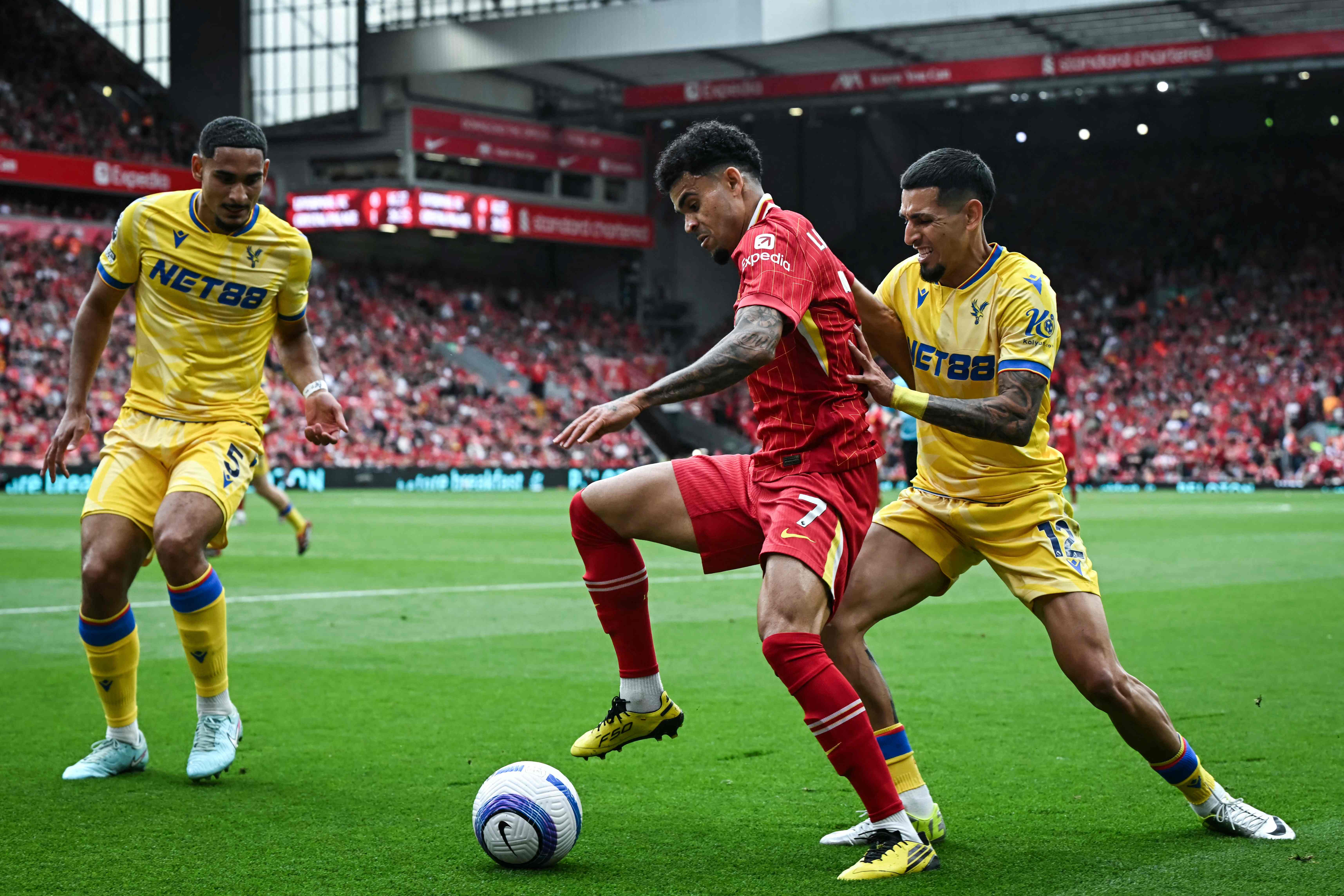 Crystal Palace's French defender #05 Maxence Lacroix (L) and Crystal Palace's Colombian defender #12 Daniel Munoz (R) fight for the ball with Liverpool's Colombian midfielder #07 Luis Diaz during the English Premier League football match between Liverpool and Crystal Palace at Anfield in Liverpool, north west England on May 25, 2025. (Photo by Paul ELLIS / AFP) / RESTRICTED TO EDITORIAL USE. No use with unauthorized audio, video, data, fixture lists, club/league logos or 'live' services. Online in-match use limited to 120 images. An additional 40 images may be used in extra time. No video emulation. Social media in-match use limited to 120 images. An additional 40 images may be used in extra time. No use in betting publications, games or single club/league/player publications. /