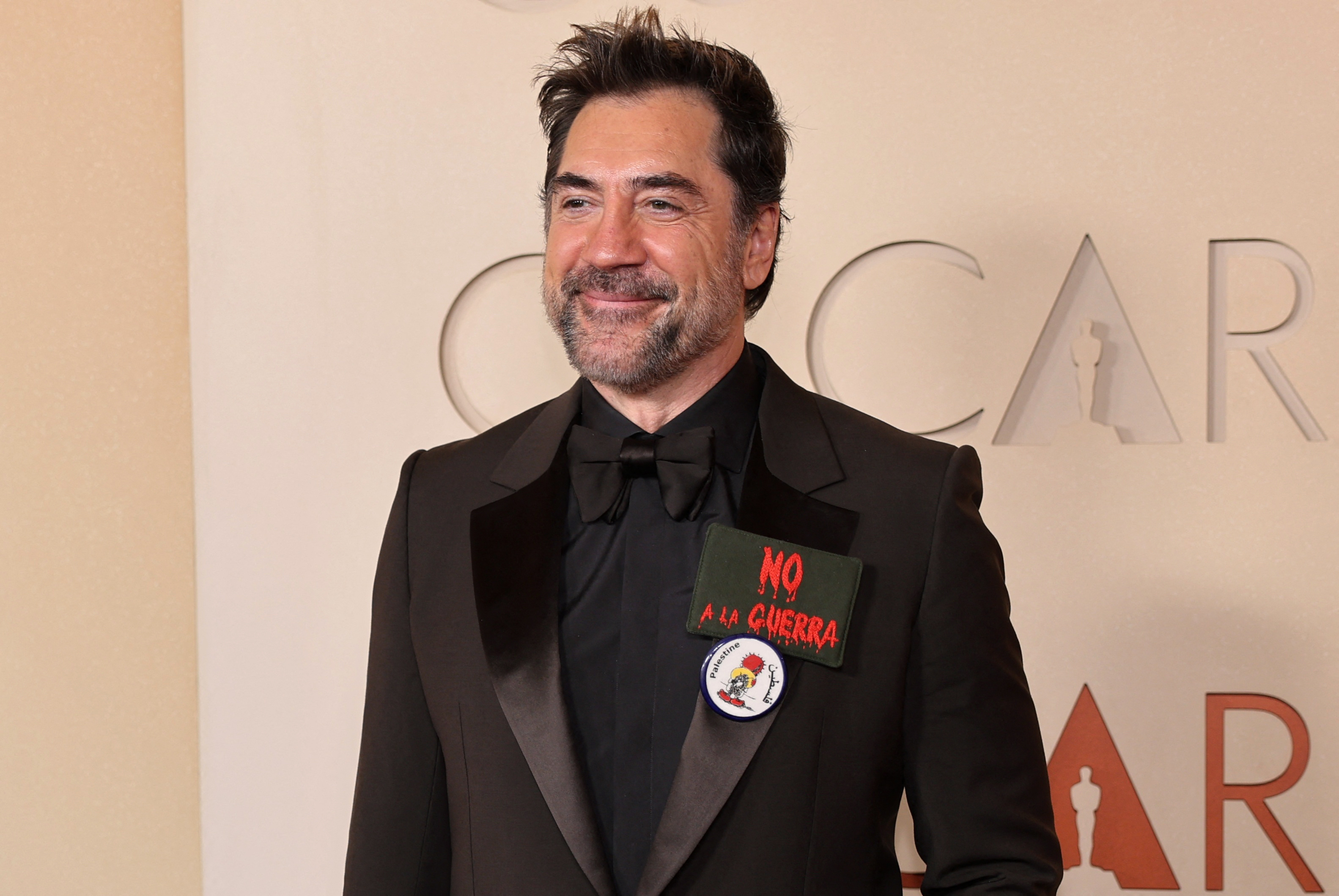 Javier Bardem wears a pin which reads: "Palestine", and an anti-war sign, on the red carpet during the Oscars arrivals at the 98th Academy Awards in Hollywood, Los Angeles, California, U.S., March 15, 2026. REUTERS/Daniel Cole