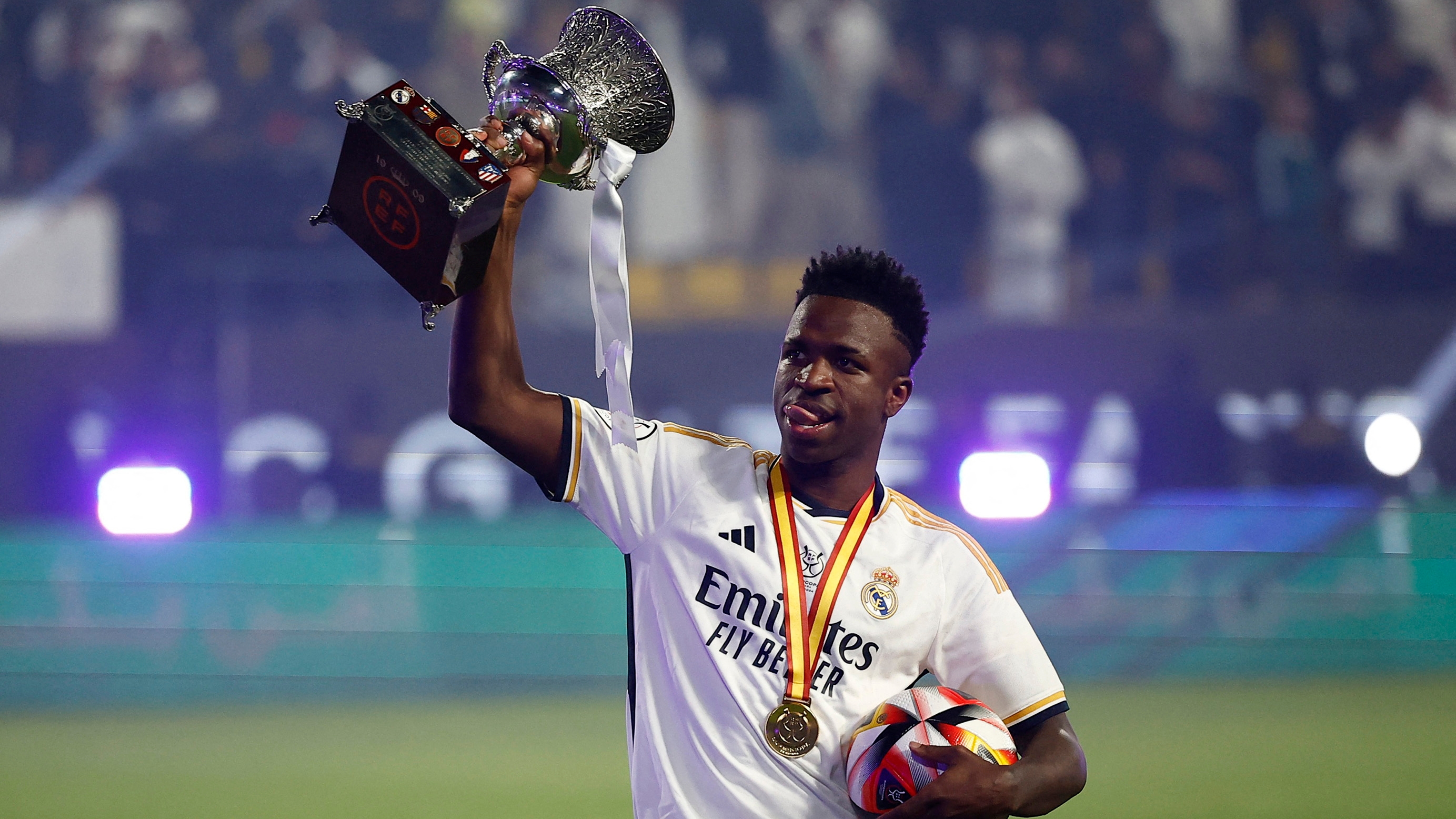 Vinicius, el protagonista de la final, levantan el trofeo de la Supercopa y sostiene con la otra mano el balón que se llevó por su 'hat-trick' al Barcelona.