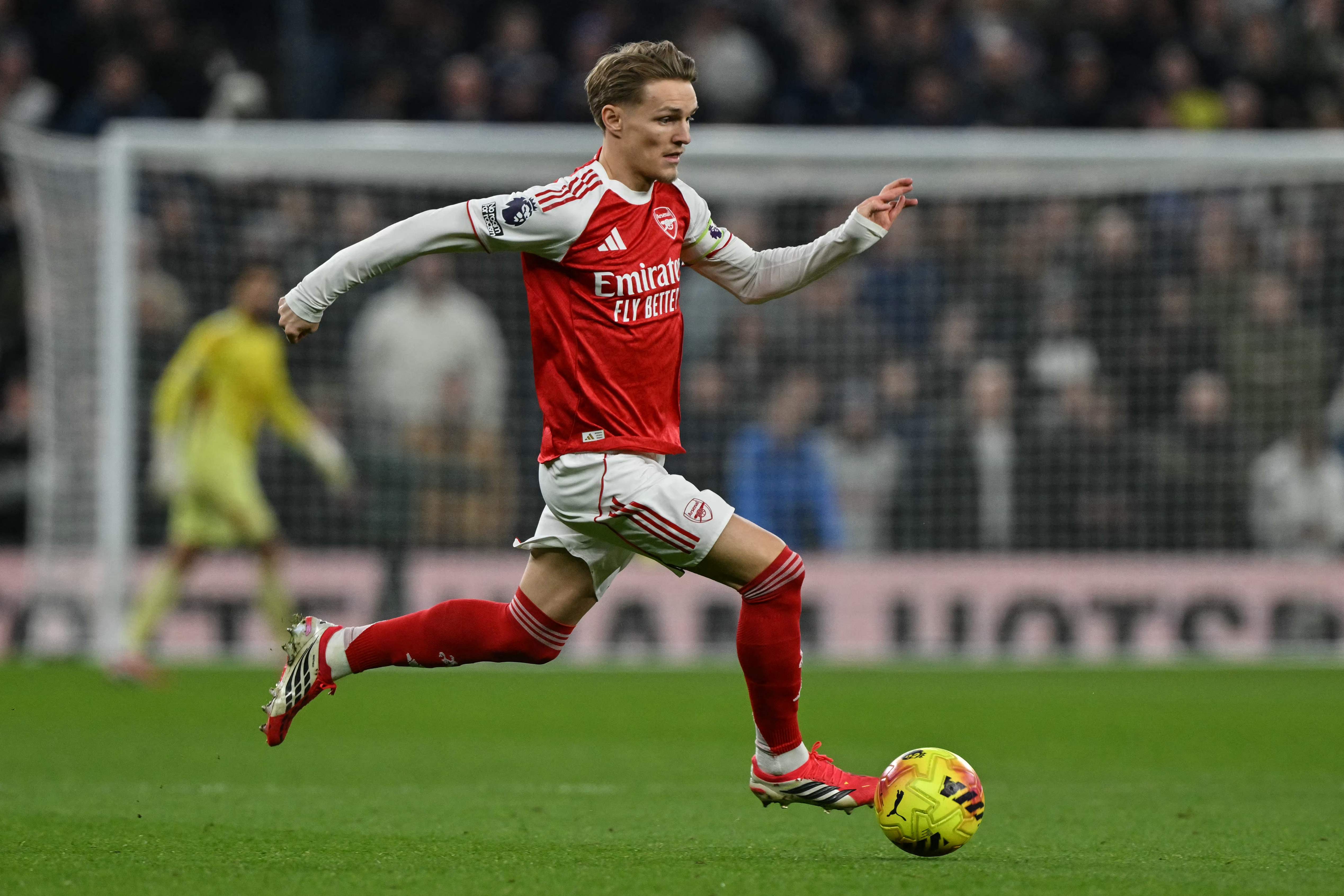 Arsenal's Norwegian midfielder #08 Martin Odegaard runs with the ball during the English Premier League football match between Tottenham Hotspur and Arsenal at the Tottenham Hotspur Stadium in London, on February 22, 2026. (Photo by Glyn KIRK / AFP) / RESTRICTED TO EDITORIAL USE. No use with unauthorized audio, video, data, fixture lists, club/league logos or 'live' services. Online in-match use limited to 120 images. An additional 40 images may be used in extra time. No video emulation. Social media in-match use limited to 120 images. An additional 40 images may be used in extra time. No use in betting publications, games or single club/league/player publications. / 