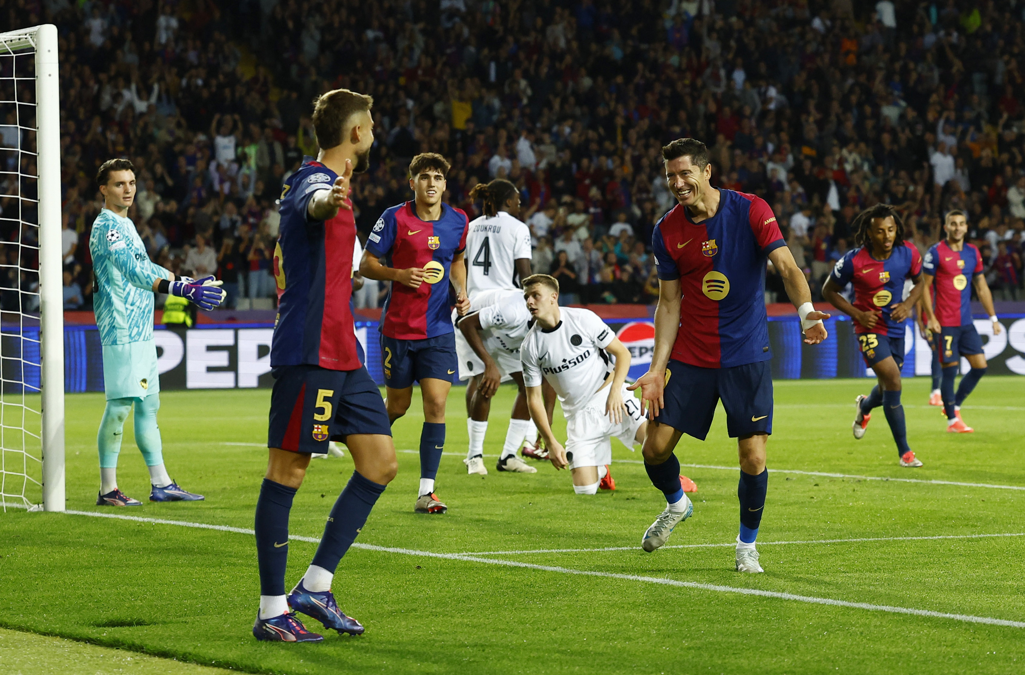 Soccer Football - Champions League - FC Barcelona v BSC Young Boys - Estadi Olimpic Lluis Companys, Barcelona, Spain - October 1, 2024 FC Barcelona's Robert Lewandowski celebrates scoring their fourth goal with Inigo Martinez REUTERS/Albert Gea