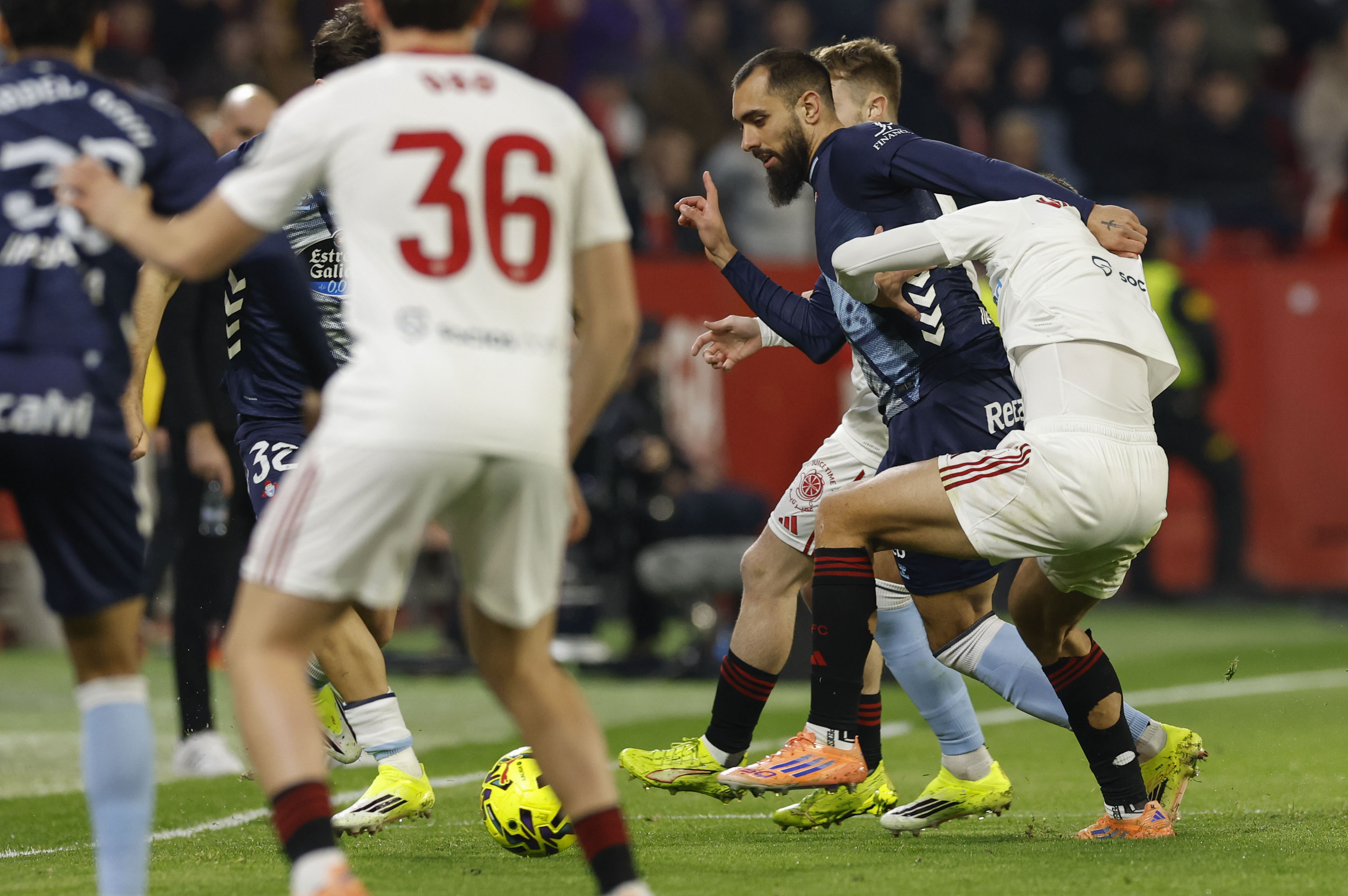 SEVILLA, 12/01/2026.- El delantero del Celta, Borja Iglesias (2d), disputa el balón ante los defensores del Sevilla durante el encuentro correspondiente a la jornada 19 de Laliga EA Sports que disputan hoy lunes Sevilla y Celta en el estadio Sánchez Pizjuán, en la capital andaluza. EFE / Julio Muñoz.
