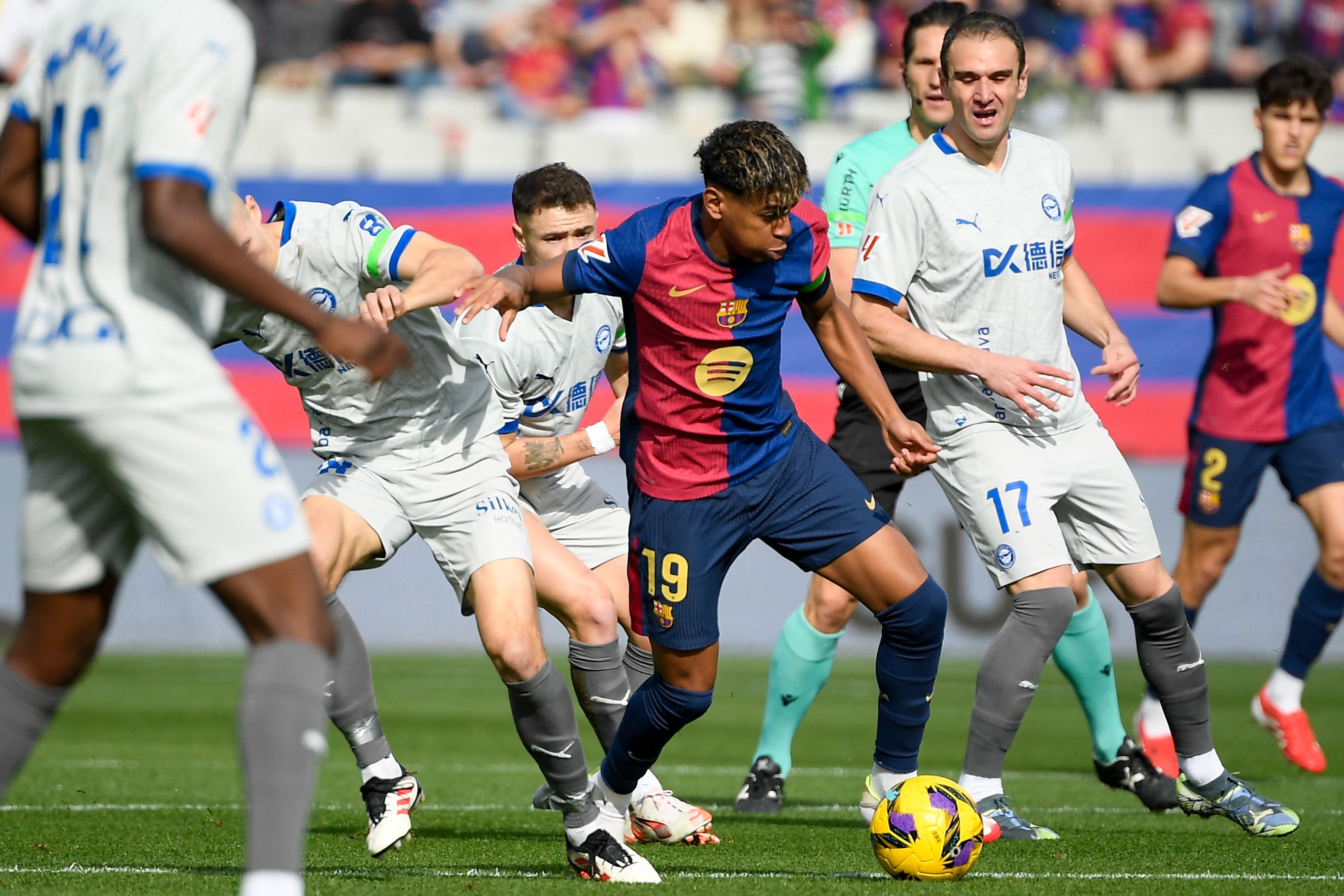 Barcelona's Spanish forward #19 Lamine Yamal (C) evades Alaves defenders during the Spanish league football match between FC Barcelona and Deportivo Alaves at the Estadi Olimpic Lluis Companys in Barcelona on February 2, 2025. (Photo by Josep LAGO / AFP)