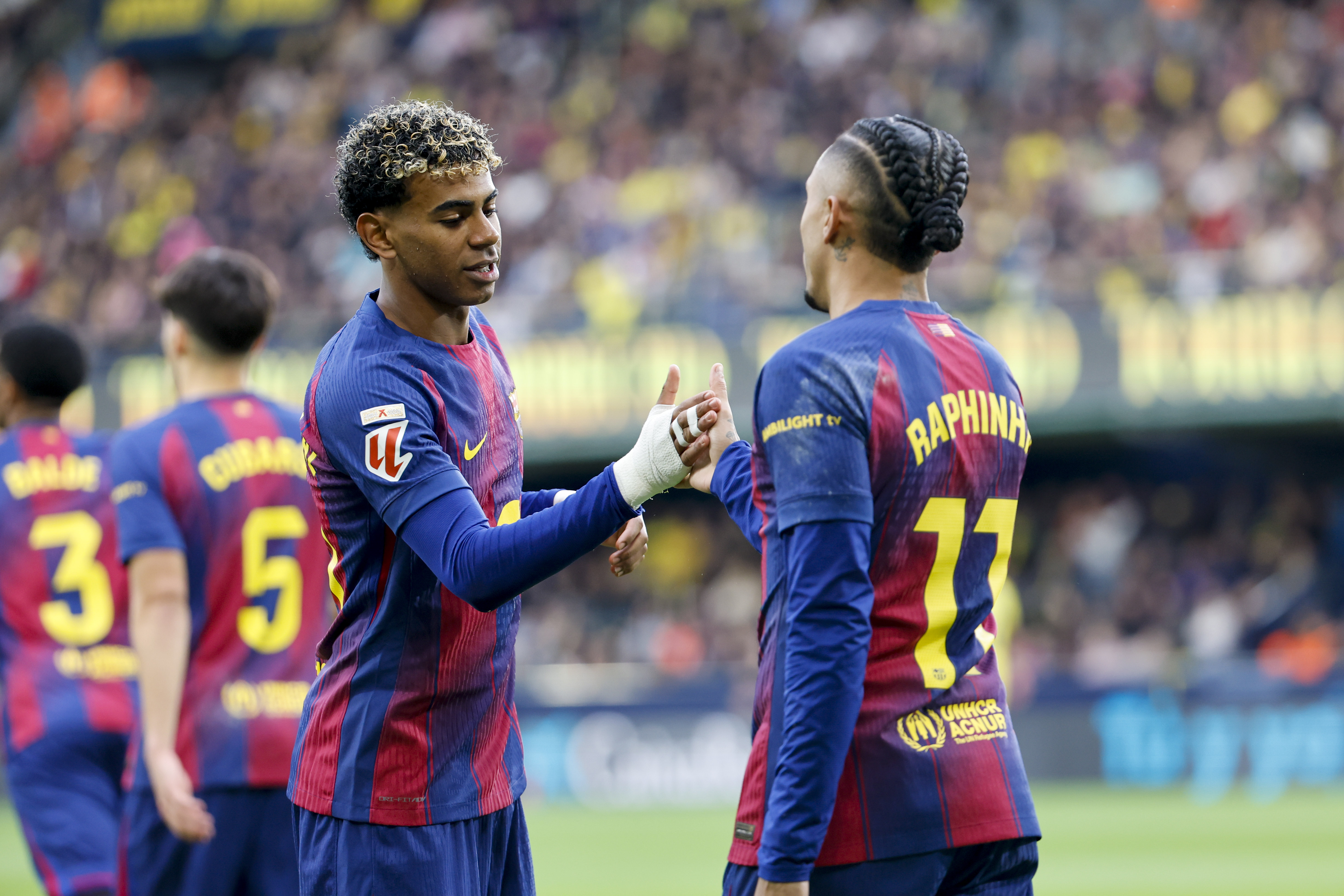 VILLARREAL (CASTELLÓN), 21/12/2025.- El delantero brasilero del Barça Raphinha celebra con su compañero Lamine Yamal tras anotar el primer gol del equipo este domingo, durante el partido de la jornada 17 de LaLiga EA Sports, que disputan Villarreal CF y el FC Barcelona en el Estadio de la Cerámica. EFE/ Ana Escobar
