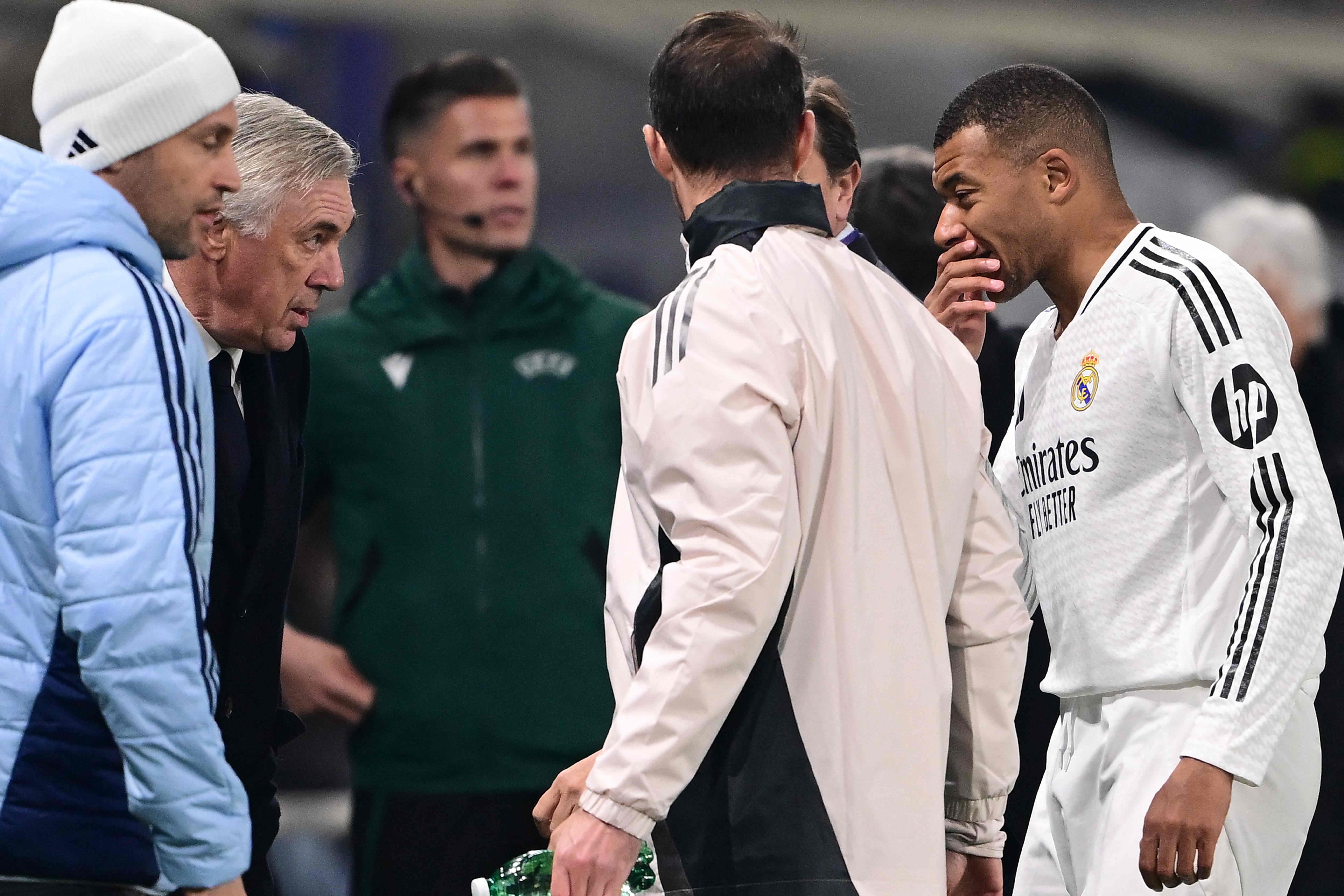 Real Madrid's French forward #09 Kylian Mbappe speaks to Real Madrid's Italian coach Carlo Ancelotti as he leaves the pitch after an injury during the UEFA Champions League football match between Atalanta and Real Madrid at the Gewiss Stadium in Bergamo, on December 10, 2024. (Photo by Marco BERTORELLO / AFP)