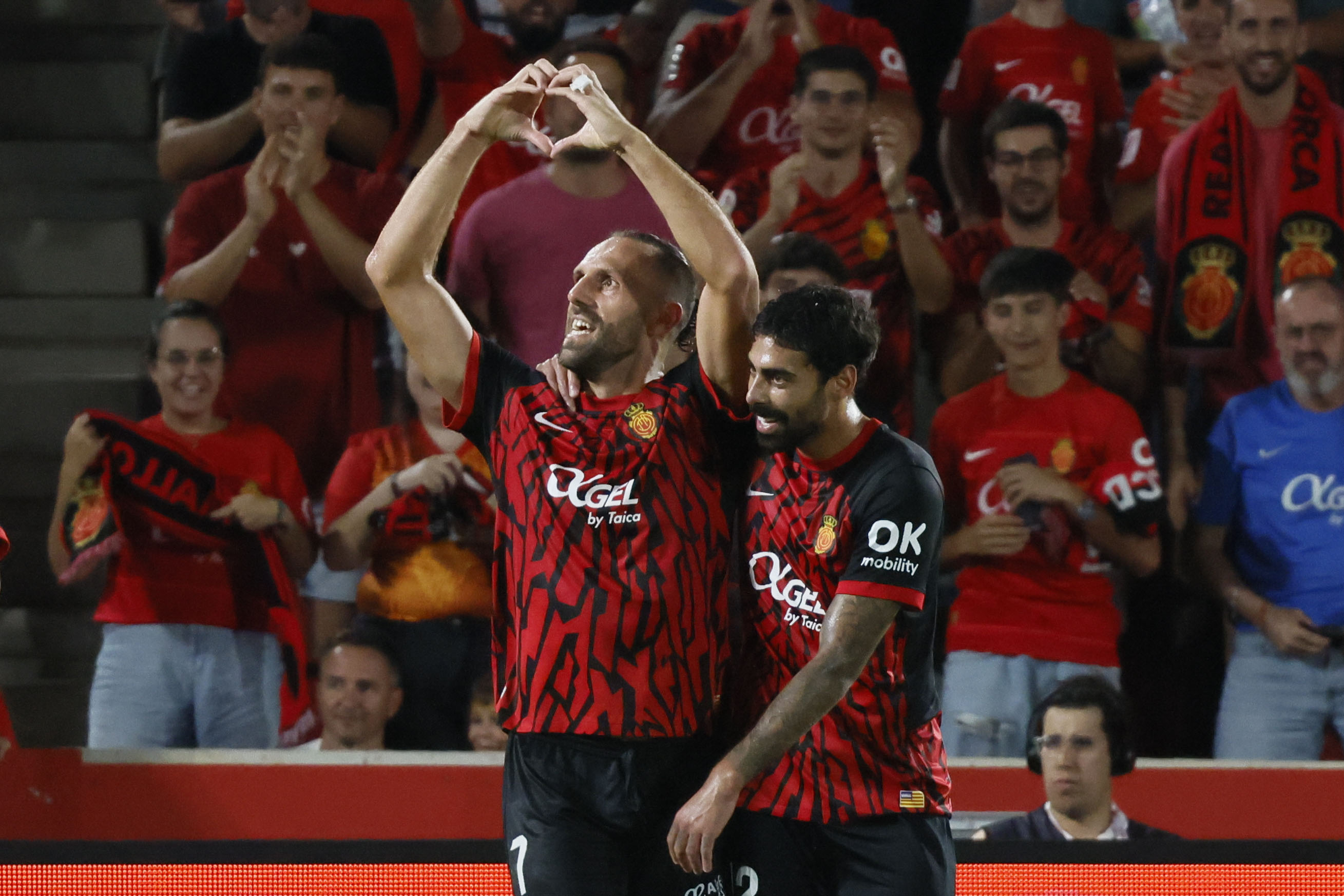 PALMA, 18/08/2024.- El delantero kosovar del RCD Mallorca Vedat Muriqi (i) celebra su gol durante el partido de LaLiga entre el RCD Mallorca y el Real Madrid, este domingo en el estadio de Son Moix, en Palma. EFE/CATI CLADERA
