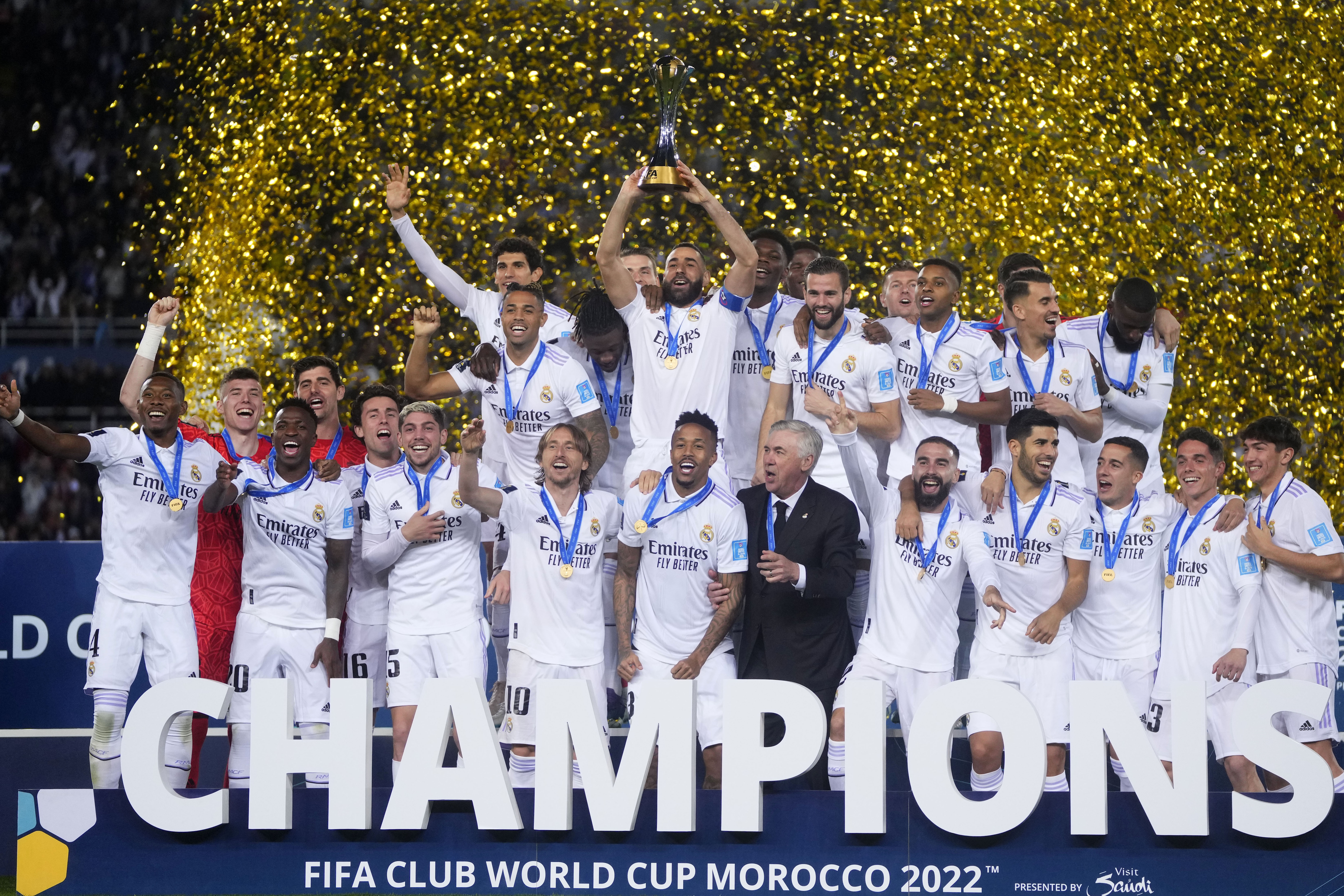 FILE - Real Madrid players celebrate with the trophy after winning the FIFA Club World Cup final match against Al Hilal at Prince Moulay Abdellah stadium in Rabat, Morocco, Saturday, Feb. 11, 2023. The United States will host the Club World Cup in 2025, the first time the FIFA tournament will have 32 teams. Real Madrid, Manchester City and Chelsea already earned places as recent Champions League winners for the expanded tournament lineup that is set to test stadiums and operations one year before the 2026 World Cup. (AP Photo/Manu Fernandez, File)