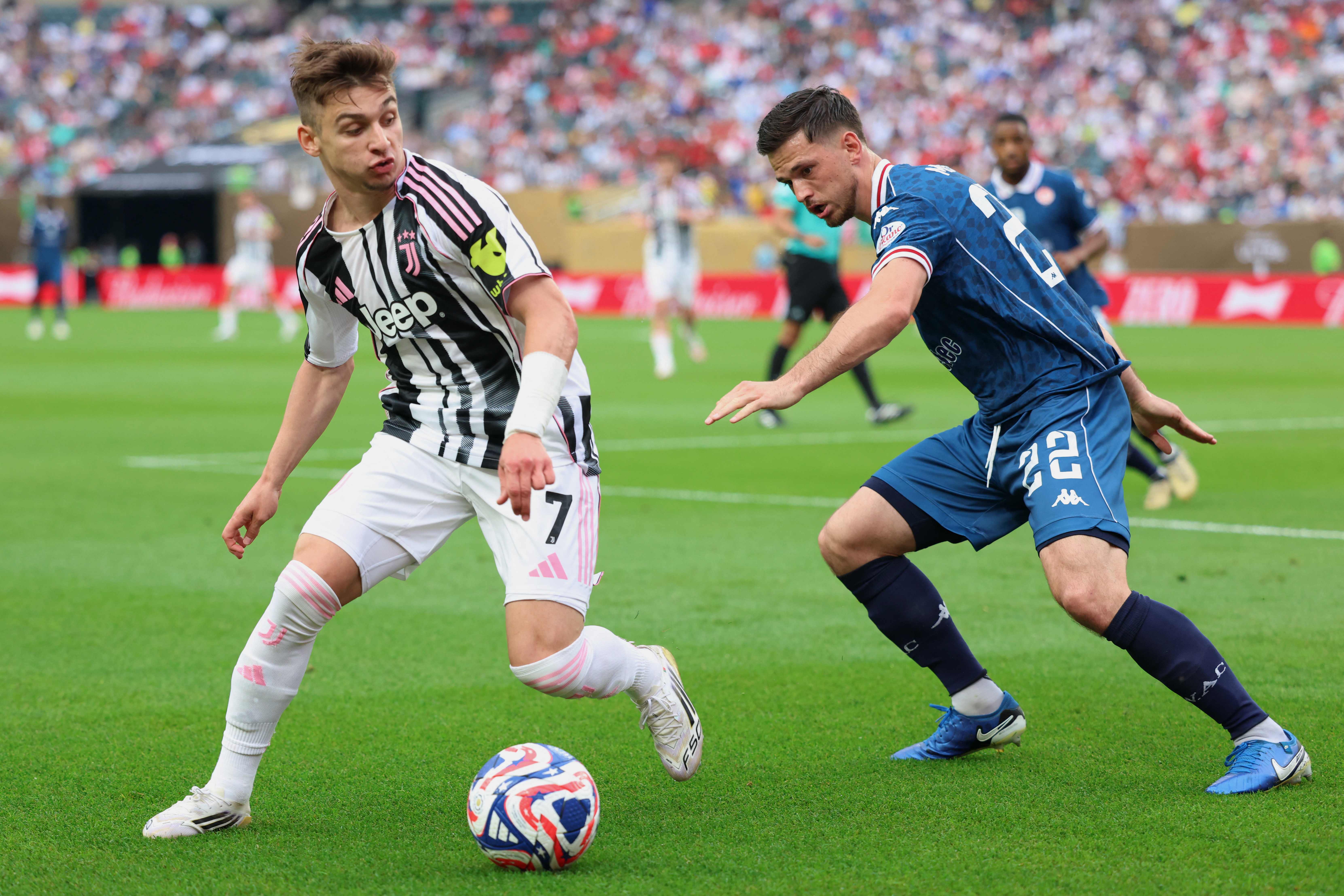 Juventus' Portuguese forward #07 Francisco Conceicao and WAC Casablanca's Dutch defender #22 Bart Meijers fight for the ball during the FIFA Club World Cup 2025 Group G football match between Italy's Juventus and Morocco's Wydad AC at the Lincoln Financial Field stadium in Philadelphia on June 22, 2025. (Photo by CHARLY TRIBALLEAU / AFP)
