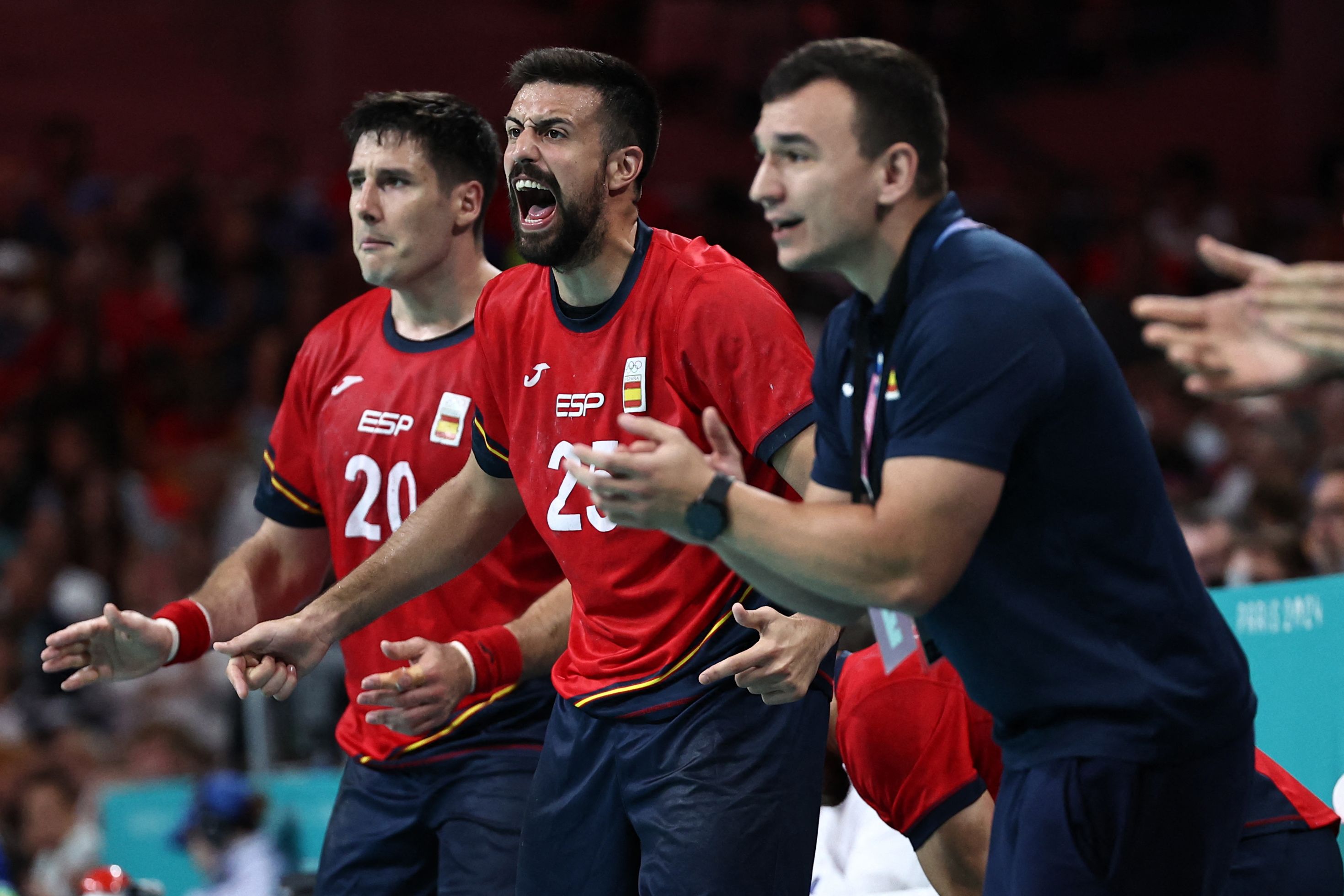 Spain's pivot #20 Abel Serdio (L) and Spain's left back #25 Agustin Casado (C) react from the bench during the men's bronze medal handball match between Spain vs Slovenia of the Paris 2024 Olympic Games, at the Pierre-Mauroy stadium in Villeneuve-d'Ascq, northern France, on August 11, 2024. (Photo by Sameer Al-Doumy / AFP)