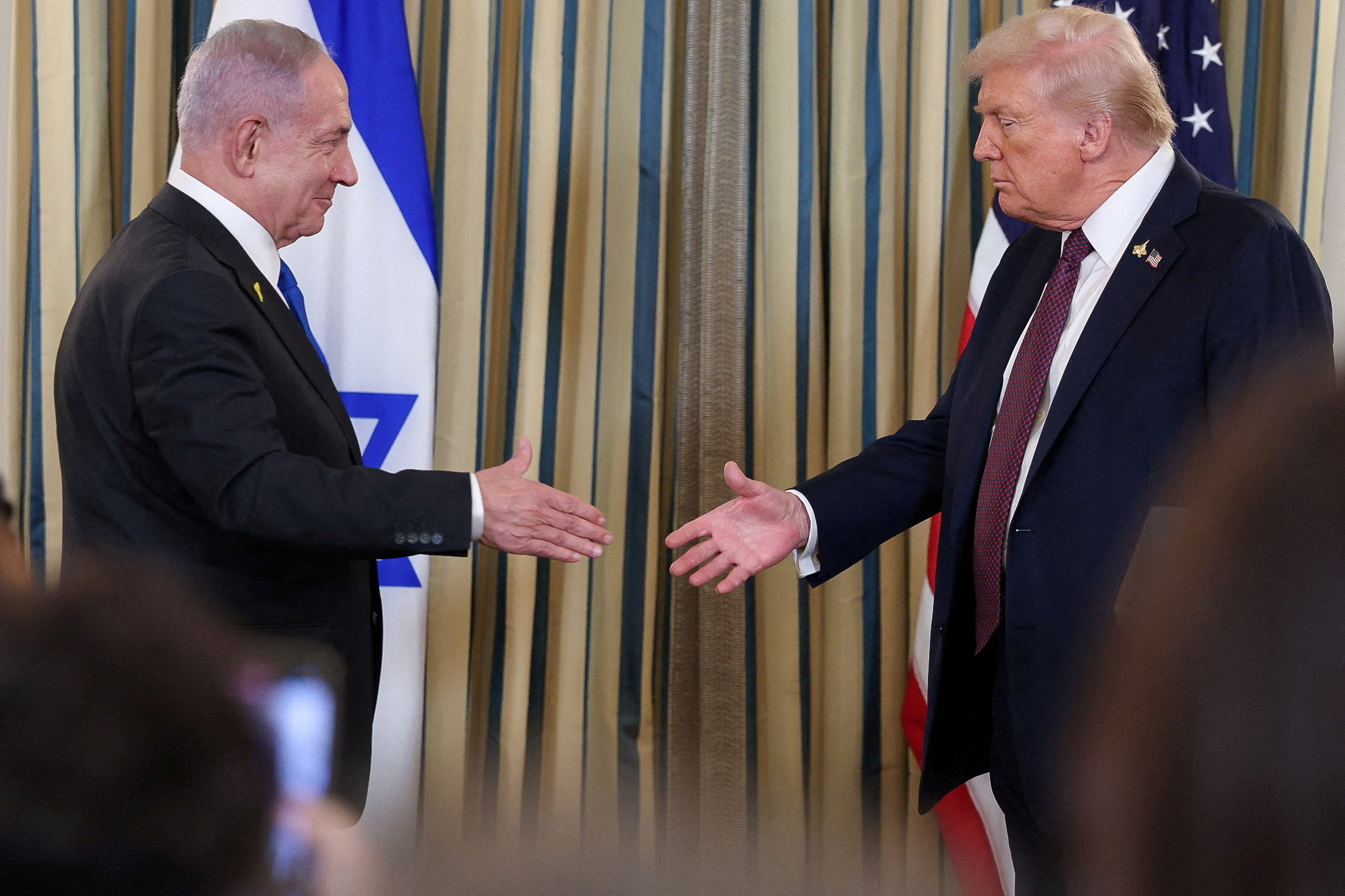 U.S. President Donald Trump and Israeli Prime Minister Benjamin Netanyahu reach to shake hands at a joint press conference in the State Dining Room at the White House in Washington, D.C., U.S., September 29, 2025. REUTERS/Jonathan Ernst TPX IMAGES OF THE DAY