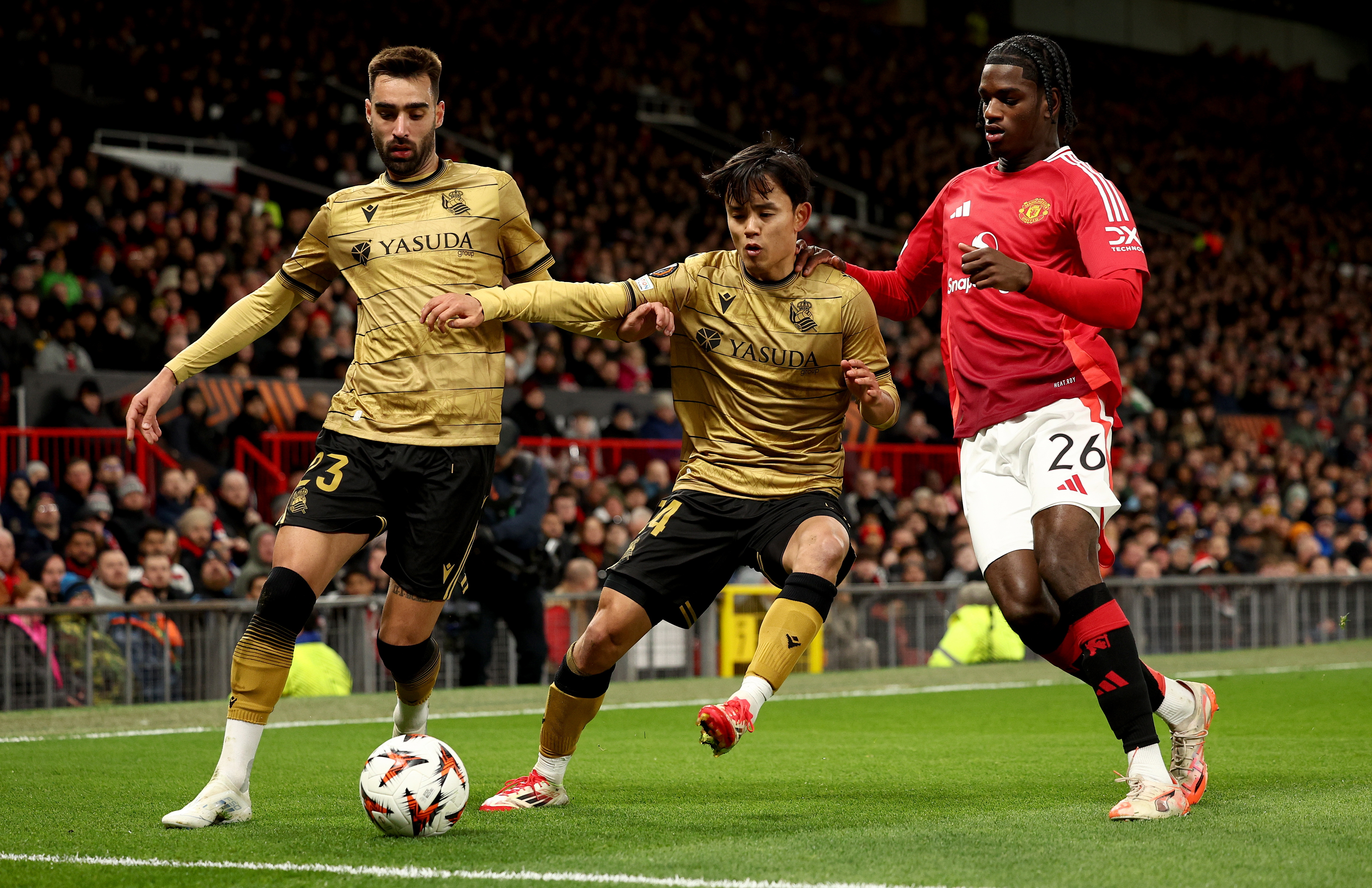 MANCHESTER (United Kingdom), 13/03/2025.- Ayden Heaven (R) of Manchester United in action against Takefusa Kubo (C) and Brais Mendez of Sociedad during the UEFA Europa League Round of 16, 2nd leg soccer match between Manchester United and Real Sociedad, in Manchester, 13 March 2025. (Reino Unido) EFE/EPA/ADAM VAUGHAN
