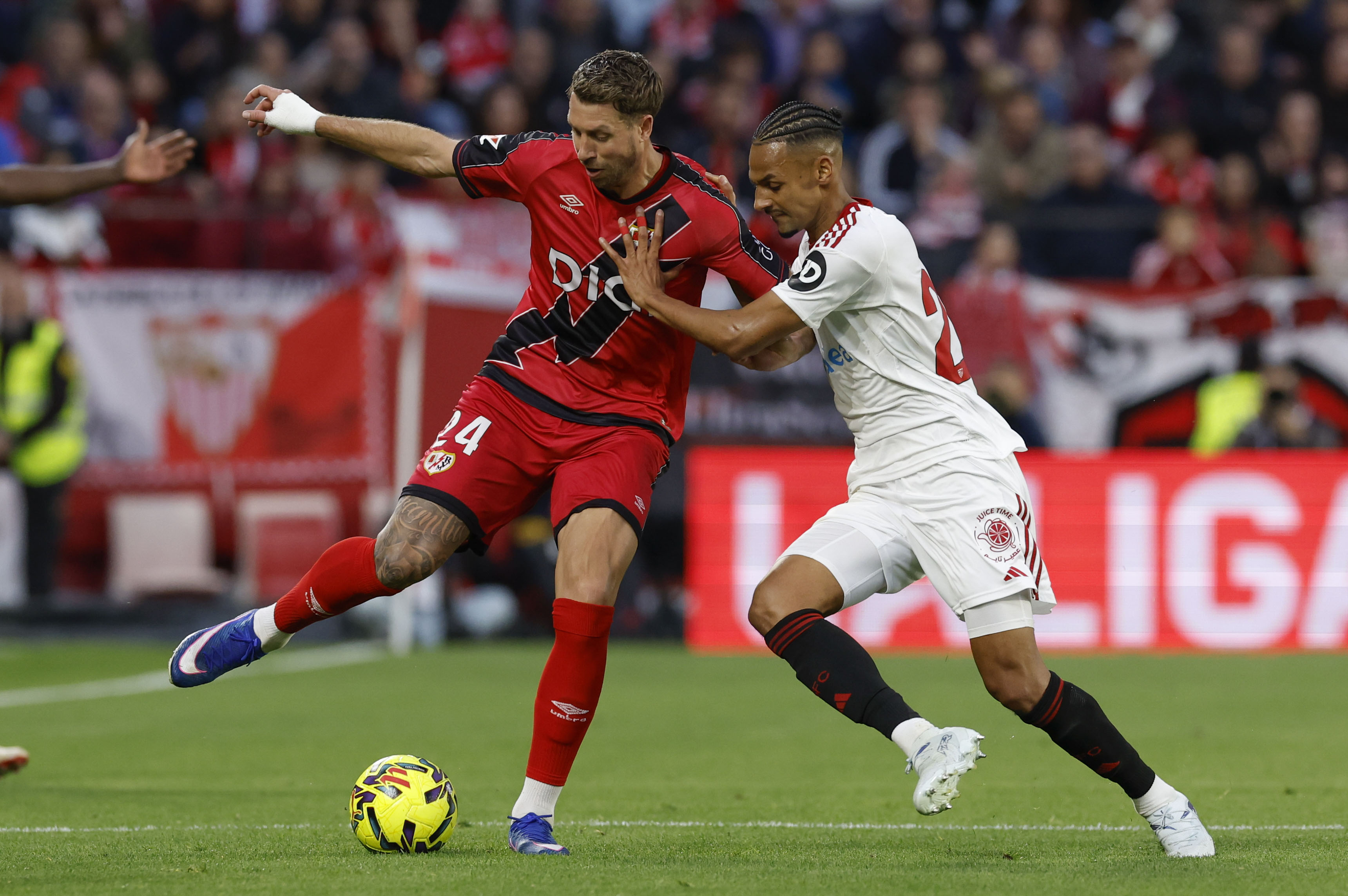 SEVILLA, 08/03/2026.- El defensa francés del Rayo Florian Lejeune (i) lucha con el suizo Djibril Sow, del Sevilla, durante el partido de la jornada 27 de LaLiga que Sevilla FC y Rayo Vallecano disputan hoy domingo en el estadio Ramón Sánchez-Pizjuán. EFE/Julio Muñoz
