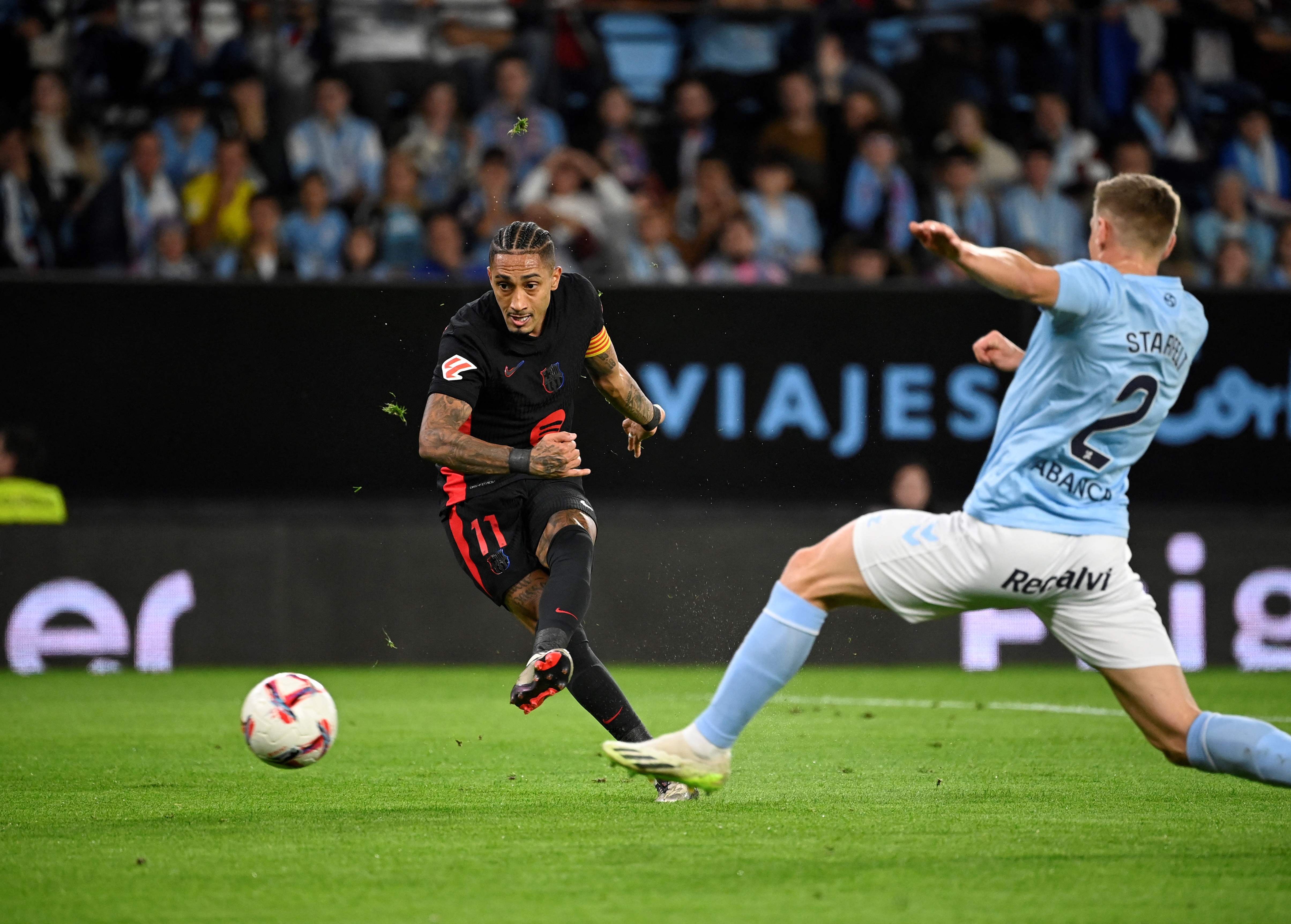 Barcelona's Brazilian forward #11 Raphinha scores his team's first goal during the Spanish league football match between RC Celta de Vigo and FC Barcelona at the Balaidos stadium in Vigo on November 23, 2024. (Photo by MIGUEL RIOPA / AFP)