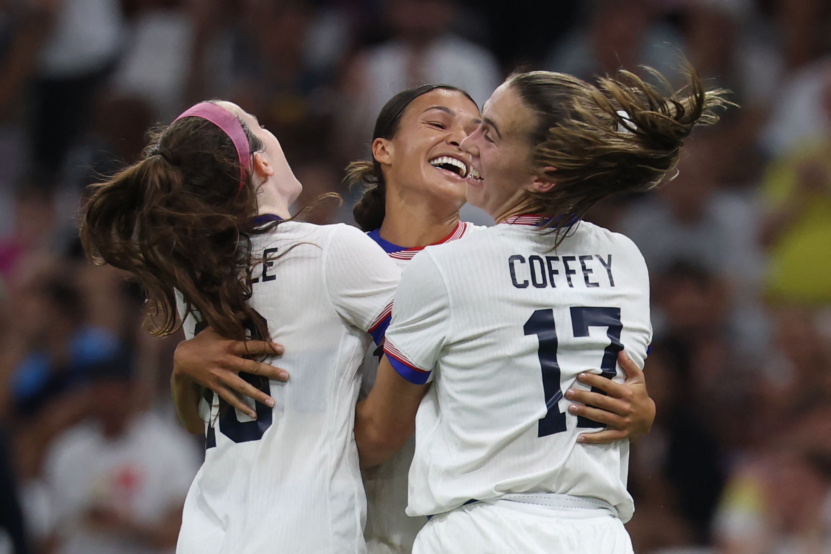US' forward #11 Sophia Smith (C) is congratulated by US' midfielder #16 Rose Lavelle and US' midfielder #17 Samantha Coffey (R) after scoring in the women's group B football match between the USA and Germany during the Paris 2024 Olympic Games at the Marseille Stadium in Marseille on July 28, 2024. (Photo by Pascal GUYOT / AFP)